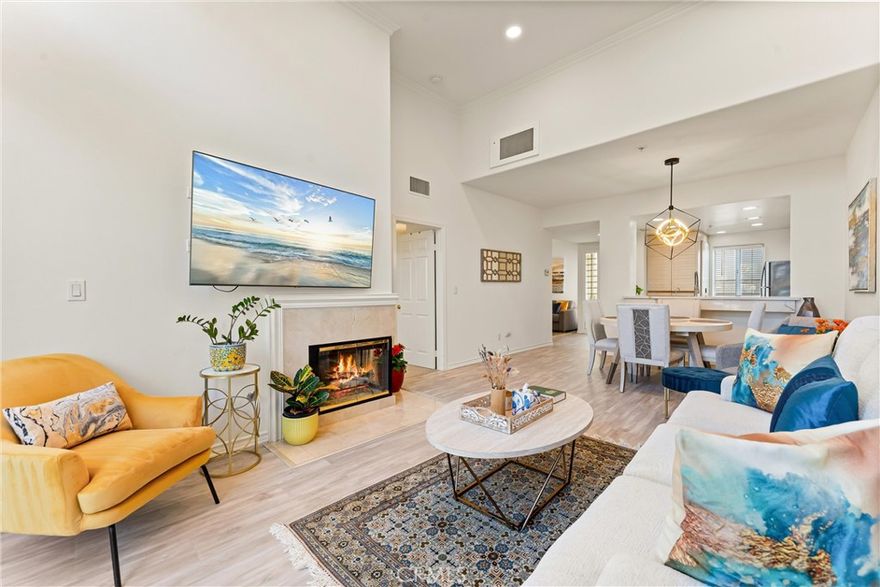 Discover Your Private Retreat in the Heart of Irvine with easy financing, including FHA and VA loans!

Experience penthouse living at its best in the coveted Metropolitan community, where comfort, convenience, and serenity meet. This turn-key top-floor residence is ideal for travelers, professionals, or anyone ready to enjoy a low-maintenance, peaceful lifestyle. Despite being just minutes from John Wayne Airport, this home feels like a tranquil escape. Conveniently located near the entrance with two side-by-side parking spaces and just steps from the elevator, this house provides effortless accessibility.

Inside, soaring 13-foot ceiling and natural light create an airy, uplifting feel. The open living space features a cozy fireplace and dining area, while the versatile den with custom built-ins offers space for a home office, hobby room, or overnight guests.

Custom features include recessed lighting, quartz countertops, new flooring, additional decorative cabinetry for storage, and a drinking water filtration system. The primary suite is spacious, offering a walk-in closet, a well-appointed en-suite bathroom, and direct balcony access. Step onto your private balcony to enjoy calming treetop views—perfect for morning coffee or evening relaxation.

The Metropolitan offers resort-like amenities, including guard-gated security, well-maintained lush grounds perfect for a relaxing stroll, a sparkling lap pool and large heated spa pool, well-equipped fitness center, and an elegant clubhouse. HOA dues include water, gas, and trash.

Schedule your private showing today and discover penthouse living designed for your next chapter!