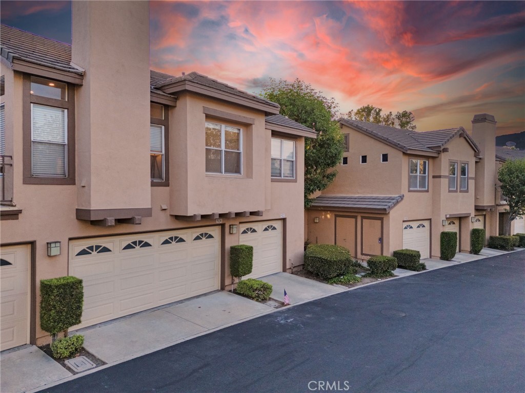 Experience stylish hillside living in the highly desirable Summit Court community of Anaheim Hills! This beautifully upgraded 2-bedroom, 2-bath home offers all living space on a single level, with a private ground-floor entry and direct access from the attached garage. A private staircase leads you to an inviting open-concept layout filled with natural light and elevated views. The spacious living room features a cozy fireplace and flows effortlessly into the dining area and remodeled kitchen—perfect for both everyday living and entertaining. The kitchen is outfitted with sleek stone countertops, a custom tile backsplash, stainless steel appliances, and abundant cabinetry. Step outside to the large balcony and take in sweeping vistas and fresh breezes. This home is move-in ready with features such as rich wood laminate floors, recessed lighting, window blinds, silhouette shades, and a crisp, modern feel that complements any décor. Both bedrooms are generously sized. The primary suite includes a large walk-in closet and remodeled en suite bath, while the secondary bedroom is adjacent to a second upgraded bathroom with a walk-in shower. Laundry is conveniently located in the attached one-car garage, and an assigned covered carport adds extra parking flexibility. Ample guest parking is also available nearby. Enjoy resort-style amenities including a sparkling pool and spa, BBQ area, fitness room, and tot lot—all set against the backdrop of scenic hilltops. Ideally located near dining, shopping, trails, parks, golf, and with easy access to the 91 Freeway and 241 Toll Road, this is Anaheim Hills living at its best!