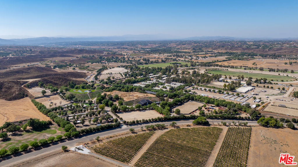 Welcome to Sweet Oaks Ranch and Winery, a breathtaking 26-acre estate in the heart of Temecula Wine Country. Spanning two parcels, this exceptional property offers a blend of luxury living, equestrian amenities, and endless recreational opportunities. The ranch features a primary residence, a spacious guest house, and two additional employee housing units, providing ample space for living, hosting, or management.The property boasts a stunning 240,000-gallon lake, serving as a picturesque backdrop for a wedding venue. Adventure and recreation abound with military obstacle courses, an ATV course, pickleball and basketball courts, and a full miniature golf course. Equestrian enthusiasts will appreciate the two barns, 30 horse stalls, a Eurociser/Horse Walker, and ample pasture space, making this property perfect for equestrian pursuits. Sweet Oaks Ranch is home to over 200 animals, offering a unique experience surrounded by nature. Zoned WC-E, this ranch is ideal for continued use as a winery or equestrian facility, with potential for expansion. Its prime location is also adjacent to the upcoming site of the 2028 Olympics, enhancing its appeal and future potential.Whether you're envisioning a private sanctuary, a working winery, or an equestrian retreat, Sweet Oaks Ranch offers endless possibilities in an exclusive setting.