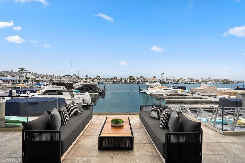 A Coastal Dreamscape Like No Other.... Nestled along the illustrious Huntington Harbor Peninsula, this sanctuary is where the rhythm of the Christiana bay meets the pinnacle of bay-side luxury. A rare jewel. Drive through the private gated Tennis Estates, where the symphony of a cascading lush green landscaping sets the tone for the serenity within. Beyond the grand entrance, a 3-story atrium bathed in natural light welcomes you, while towering 20-foot ceilings create an airy expanse that mirrors the vast water beyond. The open living spaces are designed to dissolve the boundary between indoors and out, with a striking glass bay wall offering uninterrupted views of the water’s ever-changing canvas. A versatile living room flows seamlessly onto the spacious cantilevered bay-front patio, where the ultimate in waterfront indulgence awaits— along with a 35 ft dock to moor your Duffy or boat. The ground level also includes a family/media room with a wetbar for entertaining & also a full bath with ample closets which could be converted to a 4th bedroom. Ascend the modern stunning staircase, or take the elevator to the second floor to the gourmet kitchen, a marvel of modern design, boasting top-tier appliances, custom wood cabnitry 2 large pantrys and a large island with quartz counters perfect for entertaining friends and family, with an additional formal eating area, overlooking the water. The third level reveals three bedrooms, including the opulent primary en-suite—a haven of comfort, where you"ll greet the day with the morning light dancing on the bay as you awake. Enjoy a large retreat area while sipping on your morning coffee savoring the view. A large walk in closet with built in's, a convient laundry chute and stunning bath complete the primary. The floors are beautiful hardwood on the first 2 levels and new carpets on the upstairs bedrooms. As a final touch the property offers an elevator to all 3 levels, 4 security cameras and a separate 2 car garage. Whether you're hosting a soirée under the stars, the magical Christmas Boat Parade event or just savoring a quiet sunset paradise, this is where endless summers and nautical dreams come to life. A rare fusion of elegance, adventure, and bay front magic—this is coastal living at its most extraordinary. There is no other waterfront with all the amenities this rare jaw dropper offers, make this your forever beach home or beach get away making generational memories. .
