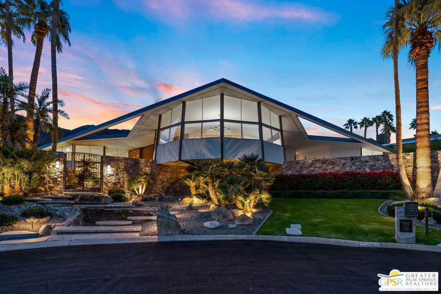 The Alexander Residence 1960 - William Krisel architect. Prolific Southern California developers and society patrons Robert Helene Alexander of the Alexander Construction Co. commissioned the spaceship-like dynamic winged home as there personal residence, a testament to engineering and daring avant-garde design that attracted Look Magazine in 1962 to declare it The House Of Tomorrow. 1967 the newlyweds Elvis and Priscilla Presley famously leased the house lending it the name The Elvis Honeymoon Hideaway Home.  A provocative entry path ushers you into an interior sunken party pad flanked by angular stacked stoned walls, glass, and a low-slung curved upholstered banquet embracing a futuristic shaped fireplace hood and floating hearth. A raised dining platform connects to a custom circular kitchen and private den with fireplace,  the grounds unfold seamlessly through a wall of glass to the expansive exterior terracing, pool, and breathtaking mountain views.A lavish primary suite is reached via a grand staircase to a private glassed perch featuring panoramic views. A generous dressing room/bathroom is concealed by built-in wardrobe closets centered around a circular tub, and an intimate balcony is accessible allowing for a discrete observation deck. All bedrooms, three lower and one upper, are en-suite, two sharing an exterior terrace. In 2021 the home went under a thoughtful renovation with restored original architectural details of stone and poured terrazzo floors, bringing the house back to it's original intent and receiving a Class-One historic designation. 2023 brought additional improvements of a higher level of luxury and sophistication. This iconic house is in the Vista Las Palmas neighborhood and is the largest Alexander-built home with the largest pool and best lot. This Special Home Is Being Sold with many of the pieces seen in the photos. Prior to viewing the property, any potential buyer must be qualified with proof of funds or letter of qualification by known financial institution