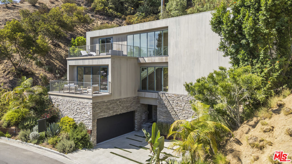 A Modern Masterpiece in Beachwood Canyon. Moments from Beachwood Village, the Beachwood Cafe, and the historic Hollywoodland gates, this home is a rare blend of modern design and timeless sophistication in one of LA's most iconic neighborhoods. Designed to capture natural light and showcase sweeping canyon views, the property is a true retreat from the cityyet just minutes from the heart of Hollywood. Clean architectural lines, walls of glass, and open living spaces define the interiors. The main level features a seamless flow from the living and dining areas to the expansive terraces outside, creating an effortless indoor-outdoor lifestyle. The chef's kitchen is both beautiful and functional, with Miele appliances, custom cabinetry, and a large island ideal for entertaining. Upstairs, the primary suite feels like a five-star hotel. Dual walk-in closets, a spa-inspired bathroom with soaking tub, and a private sun deck offer a space to unwind in total comfort. Two additional guest suites are equally well-appointed. The outdoor spaces are designed for relaxation and entertaining. A well-appointed pool and spa are surrounded by lush landscaping, with multiple areas for dining, lounging, and enjoying evenings by the firepit. Additional features include fully owned solar panels, and a two-car garage with extra parking. Tucked away in the quiet hills of Beachwood Canyon, this stunning contemporary home offers the perfect balance of privacy, style, and California luxury. Welcome home.