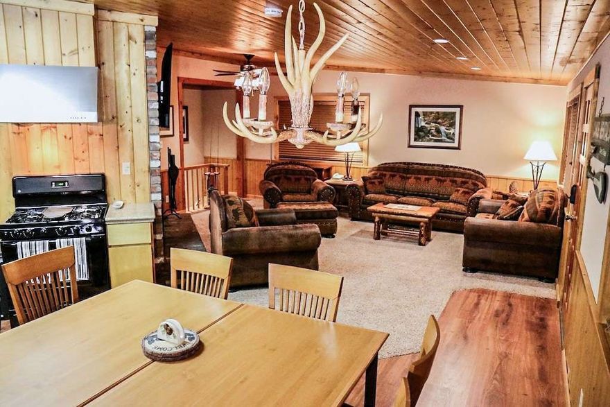 Beautiful Bass Lake Heights Cabin Smart Home. Turn key, fully furnished spotless & pristine move in ready. The home is approx.1 mile or a 3 minute drive to Bass Lake, the Forks Resort & Marina where you can moor your boat. The lake has many beaches and picnics areas. Enjoy 82º water temp. for summer swimming. A short 15 miles from the So. Entrance to world class Yosemite National Park, and an 8 minute drive to town where all the major grocery stores, and great restaurants are. This charming cozy cabin has new hard flooring & carpet. It has been a vacation rental so everything needs to be immaculate. It has Central heat & AC, almost new tankless water, a smart home to control all lights, thermostat & door locks remotely from anywhere. It is situated on a ridge just above the lake at 3400 ft elevation (we get some winter snow). Hike to the Lake on the Mono trail. Bass lake heights is situated against CA forestry land. The neighborhood is quiet, full of warm and friendly folks & Madera County winter snow removal, fire hydrants and its own mutual water company. Updated and well maintained in recent years with new concrete driveway 2 stall carport. Your home features 350º wrap around deck, 3/4 covered. Gas fire pit & BBQ plumbed into the main tank, for easy outdoor entertaining. Great cabin feeling with Knotty Pine ceilings, wainscoting, and wood trim accents. Kitchen features stainless steel sink, granite tile and custom tile back splash, appliances and pantry. The great room features large wood burning brick fireplace with heat fan for warm winter nights. A large living room. Large master suite with private bath, sitting area, a beautiful work desk and deck access. 2nd bedroom off the Great room and hall bath & deck access. 3rd bedroom downstairs & 1/2 bath with stacking washer dryer & high end elec. fireplace adds warm charm. A large storage area underneath cabin off the downstairs bedroom with a big work bench. Out the back door is a beautiful hot tub & bonus laundry room. Almost all contents included. Equipped for a whole house generator with manual transfer switch. A peaceful mountain community with beautiful cedar & pine trees is a backdrop that will elevate this retreat into something truly special. Whether you're seeking a personal getaway or a move-in-ready second home or successful vacation rental, this tranquil haven invites you to slow down, breathe deep, and live where nature leads. Don't miss out on this wonderful cabin. A must See!