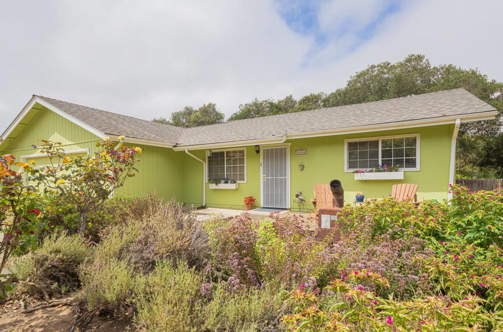 At the end of a private road w/your own gated entrance sits a charming cottage on almost a flat half acre surrounded by fruit trees, mix of climbing flowers, rose bushes,& free flowing plants that create layers of colors & fragrances (on drip irrigation) to your delight. Front porch has decking w/sitting area. Side yard has large wood deck for entertaining + greenhouse & storage shed. Fenced in cement area for firewood, chicken coop, or pets. That is just the outside. For the inside is a welcoming living rm w/free standing wood stove flowing into the kitchen w/oak cabinets, corian coutertops, & nice appliances. A sunroom to enjoy your morning cup of coffee/tea or evening glass of wine. Kitchen has cozy area for dining or office space w/double sliding doors to fenced back yard. Full guest bath too! 2 full bedrooms w/lots of closet space. Primary has own bathroom suite. Double pane windows & tile flooring throughout. Access to large 2 car garage off living rm. There is Solar & Tesla battery backup. Partially fenced & supper commute location all directions. Definately stop and smell the roses on this one.