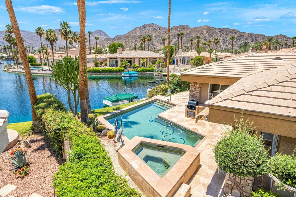 Lakeside - Don't miss this rare opportunity for lakefront desert living! With stunning panoramic views of the Chocolate Mountains, this former model home is located in the highly sought-after gated community on Lake La Quinta. Every detail of this property exudes sophistication from its pristine lakefront setting to its meticulously-maintained landscaping. The well-thought-out design maximizes views, providing seamless indoor-outdoor living. It serves as a private sanctuary as well as an entertainer's paradise with a full-sized wet bar, spacious kitchen, outdoor gas barbecue, pool, spa, and electric awning for enjoying the stunning views. Thanks to the private dock, you can cruise around the lake in your own boat. The beauty carries on inside. From your primary bedroom, continue to enjoy mountain and lakefront views with access to your outdoor patio. This room also includes a spacious ensuite bathroom with bathtub, shower, walk-in closet, toilet and separate bidet. Adjacent to the primary bedroom is a second bedroom with an attached bathroom. On the other side of the house is a third bedroom with its own private bathroom. The rooms are spacious yet easy to clean thanks to the central vacuum system. Faux painting on the walls, not wallpaper. A 25 acre community pool, tennis courts, bocce ball and more, a friendly neighborhood awaits. Resort style living with the best views on Lake La Quinta!