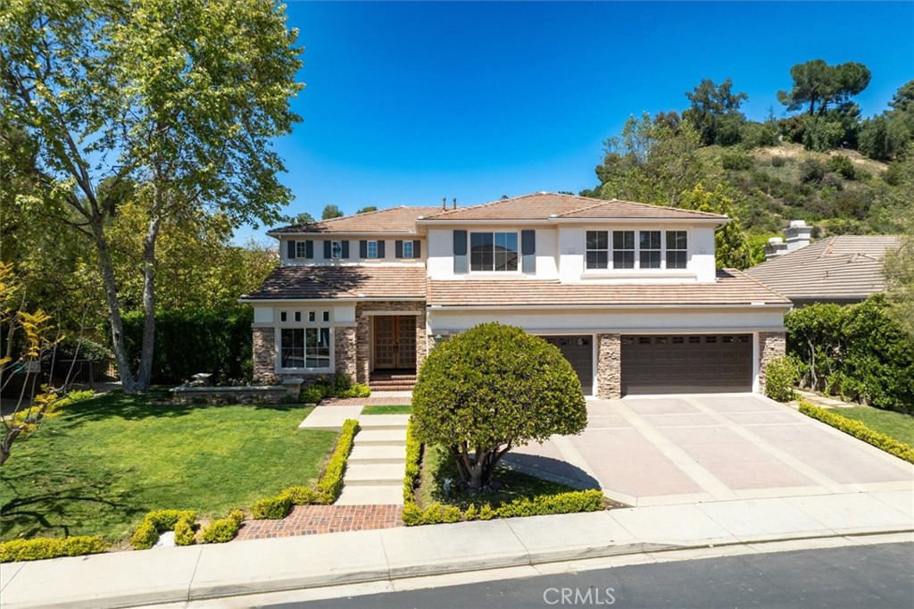 INCREDIBLE VALUE! Tucked away within the prestigious guard-gated enclave of Summit Point Estates, this exquisite five-bedroom, four-and-a-half-bath residence offers the perfect blend of timeless elegance and modern luxury. Situated at the end of a peaceful cul-de-sac, the home welcomes you with a stately double-door entrance that opens to soaring 30-foot ceilings and a bright, thoughtfully designed floor plan ideal for both refined entertaining and everyday living. The grand formal living and dining rooms exude sophistication, seamlessly flowing into a chef's dream kitchen—beautifully appointed with dual center islands, top-of-the-line Thermador appliances, and an abundance of custom French country cabinetry. The adjacent family room, anchored by a cozy gas fireplace, offers a warm and inviting ambiance, while the charming breakfast island provides the perfect spot for casual dining. A well-appointed guest suite with a private bath completes the main level, ideal for visiting family or friends. Upstairs, the expansive primary retreat features a serene sitting area, dual walk-in closets, and a luxurious en-suite bath with double vanities, soaking tub, and separate shower. Three additional bedrooms—two sharing a Jack-and-Jill bath and one with a private en-suite—provide ample space for family or guests. Walls of glass open to the resort-inspired backyard, where lush landscaping surrounds a sparkling pool and spa, expansive lawn, and covered patio—offering an idyllic setting for entertaining or tranquil relaxation. A finished four-car garage, complete with a 220-volt EV charger, adds to the home's exceptional amenities. Located in the scenic Santa Monica Mountains, just minutes from hiking trails, premier shopping and dining at The Village, and the iconic beaches of Malibu—this is California living at its finest.