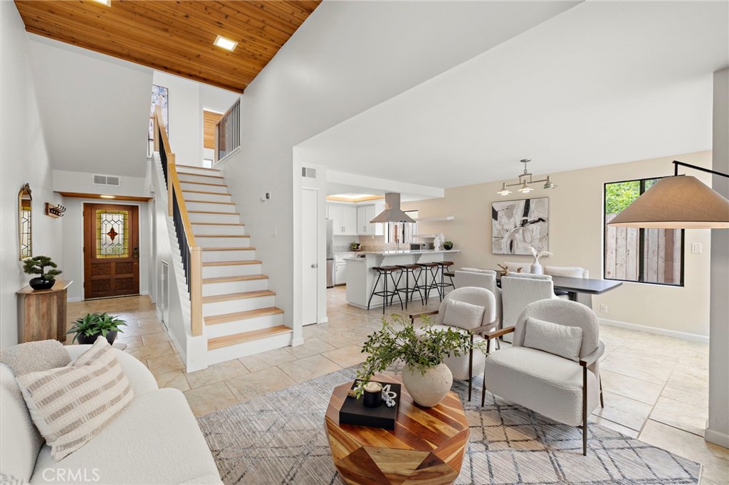 Step into comfort, style, and coastal charm with this beautifully refreshed 3-bedroom + loft, 2.5-bath townhome in the heart of North Redondo Beach. Tucked away in a quiet, well-maintained community, this desirable end-unit shares only one wall and features a rare private backyard retreat—complete with a spacious, sun-soaked deck ideal for lounging, grilling, or dining al fresco. Inside, you're welcomed by soaring wood-beamed ceilings and a striking fireplace that create a warm, inviting atmosphere. The open-concept layout connects seamlessly to a thoughtfully updated kitchen equipped with quartz countertops, sleek stainless steel appliances, a breakfast peninsula, modern cabinetry, and a roomy pantry. A cozy sunroom just off the kitchen brings in natural light and opens to the backyard, blending indoor and outdoor living. Upstairs, the vaulted-ceiling primary suite offers a peaceful escape with its own private balcony and upgraded en-suite bath. Two additional bedrooms and a remodeled full bathroom complete the second level. A new custom handrail leads to a versatile loft—perfect for an office, gym, or creative space. Additional features include a new central heating system, garage laundry setup, upgraded fireplace and chimney, and an extra exterior parking space. Located near top-rated Redondo Beach schools, shopping, dining, and just minutes from the beach, this home offers the perfect blend of modern convenience and coastal living.