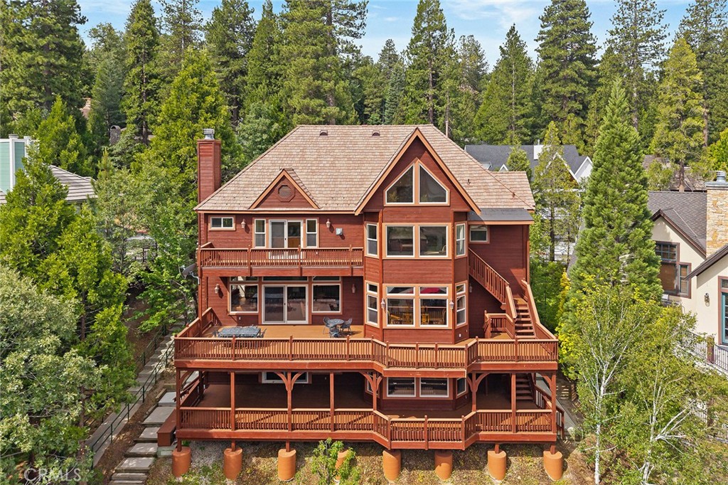 Offered for the first time since newly built! Gorgeous Mountain Theme Lake Front home located in the exclusive, gated community of Meadow Bay, with its beautiful collection of homes, mature trees and family friendly environment, this is the Lake Front home you have been looking for! Take the kids fishing along the manicured shoreline or from your private Single Slip Dock with boat lift, right in front of your home, in calm waters. This property has been meticulously maintained, new tile roof, newly rebuilt decks with the finest deck materials for long life, cell phone-controlled Lift Master garage door openers for the extra large and deep 2+ car garage with 94" tall doors for your SUV. The home is nearly 4500 square feet, with 6 bedrooms, 6 bathrooms offering two spacious Primary Suits on separate levels with beautiful lake views and access to wide open decks to enjoy morning sun or evening sunsets. The lower-level Primary suite has a bunk room attached for the little ones with built ins. This level consists of the family room with granite fireplace, gaming area, huge outdoor deck and the Wine Cellar! Upper-level Primary suite is a showcase with walls of windows bringing in the natural light, peaked beam with wood tongue and groove ceiling, granite stone fireplace and spa like bath with relaxing jacuzzi tub, separate stone tile shower, dual sinks and huge walk-in closet. Also, upstairs is another bedroom suite and a Jack and Jill set of bedrooms with attached bathroom. The Main Level is set up for entertaining with an open floorplan kitchen offering Viking appliances, granite counter tops, large dining area, enormous breakfast bar, all open to the great room with granite stone fireplace perfect for celebrating the holidays with family and friends. Built ins and window wall opening to newly rebuilt deck for outdoor dining and enjoying the lake. Executive style office with built ins is also located on the main floor. Very functional home with large laundry room including a sink, storage and laundry chute from the upper floor. Huge Pantry off the kitchen is a dream, the home has tremendous storage throughout, including walk-in closets for storing holiday items and a large storage room accessed from the outside as well as from the interior. New LED lighting, new concrete driveway and new concrete steps on both sides of the house. Many expensive upgrades will give many years of trouble-free enjoyment. See Matterport floor plans and walk through video.