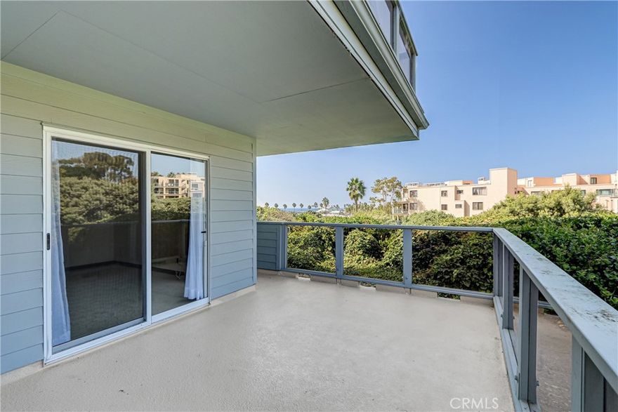 Location, location, loaction. Turnkey end unit in the heart of coastal living, just steps from the beach, boardwalk, dining and entertainment.  1 nice size bedroom with 2 closets and a den ( perfect for a home office).  Nice size kitchen with stainless appliances opens up to a huge open livng room/ dining room combo with lots of windows and brand new carpet.  The full bath is nicely updated.  Both the bedroom and living room open up to an expansive balcony with views of the harbor/break water and the greenbelt.  Secure 2 side-by-side parking with ton of storage. Enjoy resort style livng with gated pool and spa.