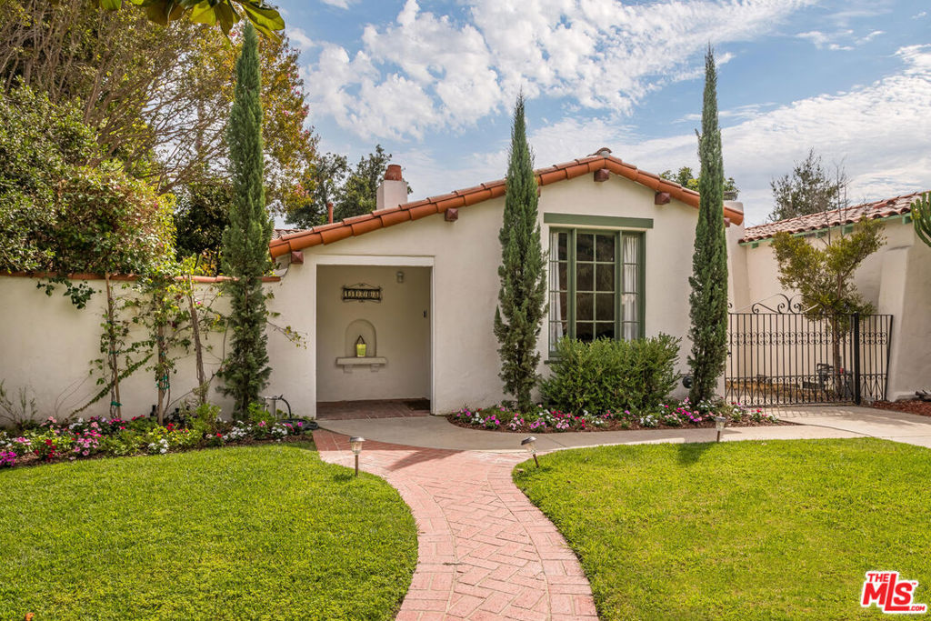 For lease unfurnished: $11,000/mo. Furnished is $13,000/mo. Discover timeless elegance in this captivating Spanish gem, rich with character and romantic allure. A red tile roof and graceful archway welcome you into a grand living room with wood beamed barreled ceilings, gleaming hardwood floors, a classic fireplace, and French doors opening to a serene courtyard with a trickling fountain. The formal dining room flows into a sunlit galley kitchen with stainless steel appliances and cozy breakfast nook, perfect for morning coffee. A cheerful pantry adds vintage charm and practicality. Four spacious bedrooms offer comfort and retreat, including a generous primary with en-suite bath with newly "penny" tiled floor. The luxurious guest bath stunning renovation has been recently completed. The 4th bedroom or versatile den/office connects to the expansive backyard with fruit trees, and a detached 2 car garage offers ADU potential and room for a pool. Set on a picturesque West Toluca Lake Street near the vibrant Toluca Lake Village cafes, restaurants, and shops. This home is a rare treasure. Homes of this character and soul are rare indeed. Come claim it before it is gone!