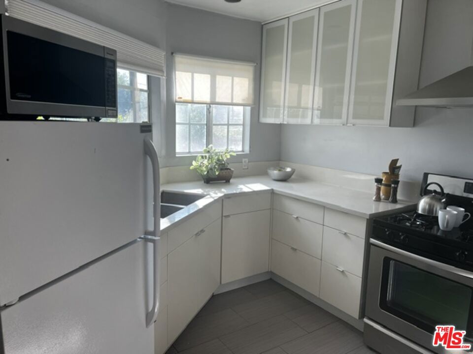 Discover classic Mid-City charm with abundant potential to live in or develop at 1770 Hauser Blvd. This beautifully fenced and gated property welcomes you with a large sun-drenched front yard and a rare sense of privacy. Step inside to find a bright west-facing living room with a faux fireplace and original built-in cabinets, perfect for cozy evenings or entertaining friends. The spacious layout includes two inviting bedrooms sharing a Jack and Jill bath, complemented by versatile bonus rooms and sunny updated kitchen. Enjoy the luxury of a private side yard-ideal for gardening, pets, BBQs or relaxation and parking for up to 3-4 cards behind the secured gate. Surrounded by some newer developments and yet tucked away mid-block, this home offers easy access to Los Angeles's best while providing a peaceful retreat with only one neighbor. Move in, expand or re-imagine----endless possibilities await in this thriving neighborhood. Property sold in it's AS IS condition with no credits or repairs.