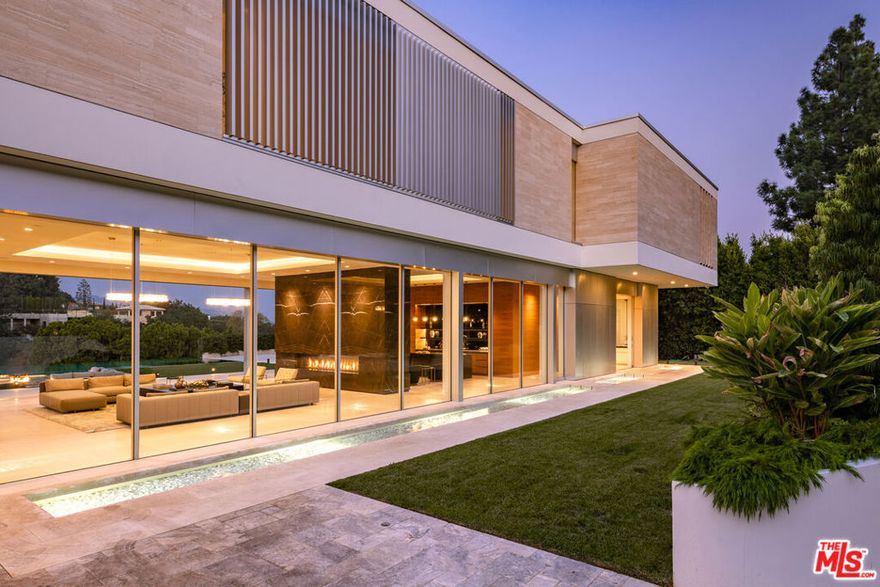 Extraordinary Estate by London-based Quinn Architects is a True Embodiment of Modern Luxury! Designed to impress, the home offers approximately 14,438 square feet of meticulously curated living space with floor-to-ceiling glass walls that showcase breathtaking panoramic views, set on nearly an acre of prime Lower Bel-Air real estate. The residence features an array of high-end amenities, including a grand glass atrium, expansive living areas, a chef's kitchen and an additional secondary prep kitchen. The main level provides a seamless flow between indoor and outdoor spaces, perfect for both intimate gatherings and large-scale entertaining. The upper level is dedicated to a sumptuous master suite, spanning around 2,100 square feet including a large private terrace complete with a spa and fire pit, and stunning views of the Bel-Air Country Club and city lights. The lower level is designed for ultimate relaxation and entertainment, featuring a game lounge with a bar, a state-of-the-art gym, a movie theater, and a temperature-controlled wine cellar. Additionally, the estate includes four spacious guest suites, a staff suite, and numerous outdoor amenities. The property is completed by a 65-foot infinity-edge pool, lush lawns, and ample patio spaces that extend the living area outdoors. This estate is a blend of contemporary elegance and sophisticated design. Truly a paragon of luxurious living in one of the most coveted locations in Lower Bel-Air.