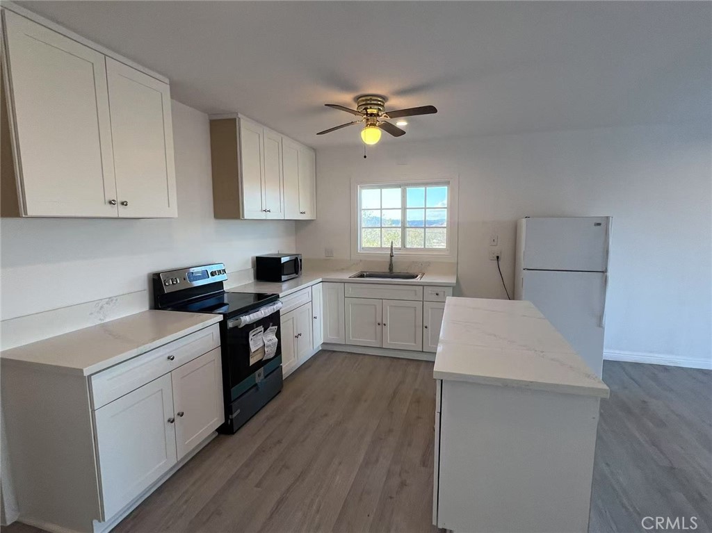Newly remodeled and move-in ready, this private 5-acre desert retreat offers panoramic views and flexible living potential in the heart of Landers. Recent upgrades include new flooring, custom cabinetry, fresh interior paint, recessed lighting, and a modern tiled walk-in shower. The kitchen features brand-new stainless steel appliances. A fully enclosed sunroom provides bonus space ideal for an office, studio, or guest room. The oversized 800 SF detached garage/workshop is perfect for storage, hobbies, or conversion to additional living space. With flat, usable land and no immediate neighbors, the property offers privacy, expansion opportunities, and strong short-term rental potential. Conveniently located near Joshua Tree, Giant Rock, and local hiking trails, this is the perfect escape for full-time living, weekend getaways, or investment income. A rare turnkey opportunity with land, upgrades, and upside—all in one.