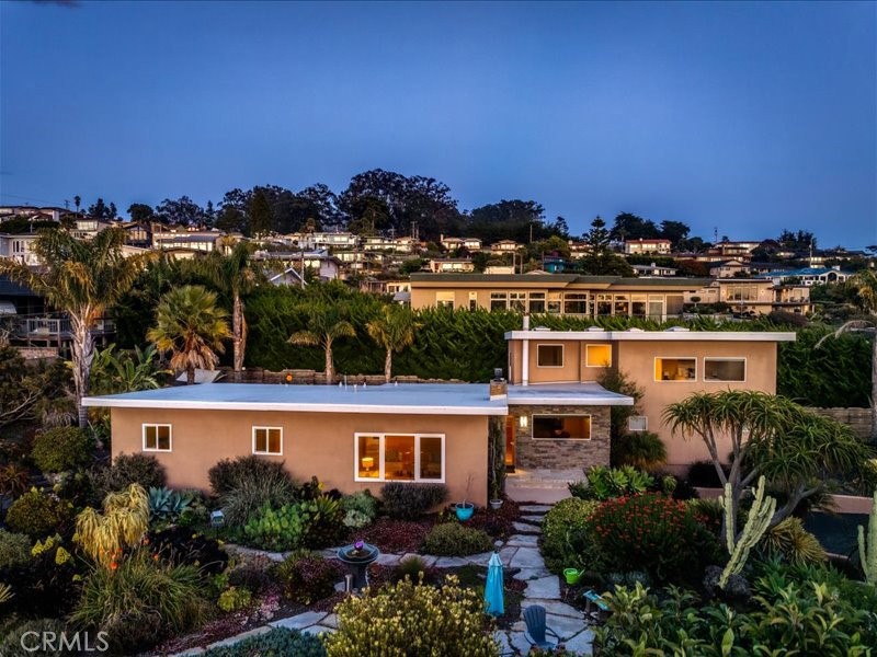Desirable Morro Heights with steps to the bay, sandpit, ocean, water and a few blocks to the golf course, state park and south end of Embarcadero- this updated four-bedroom home is supported by two and half baths, featuring about 2,103 sq. ft. of living space on an almost 1/3 acre lot. As you stroll up the few strategically paved steps leading to the front entry, your eyes will be captivated by the beautifully landscaped front yard. You will be tempted to meander around to the side and back, to check out the Jim Jacobson sculpture, Bocce Ball court, fire pit and fountain. Step past the front door, the beveled glass door opens into a welcome foyer, dining enclosure and open kitchen with granite counter tops, newer stainless steel appliances, walk-in pantry, and a breakfast bar. A hallway left of the kitchen brings you into a formal living area with a stone fireplace and views of the bay. Three bedrooms are on this same first level at the far end. Ocean views could be seen from two of the bedrooms. Wander back and past the kitchen is another foyer with access to the back yard and steps to the upper level, housing the spacious primary ensuite: featuring high ceilings, a sitting area, and ample walk-in closets. There's a separate laundry room with washer and dryer included. Upstairs, the ensuite is augmented by a primary bathroom with an inviting jacuzzi tub, separate travertine-tiled shower and plenty of storage. The home has two separate one-car garages and a small garage space for a golf cart or additional storage. At back is a spacious patio with a ground-in hot tub. There are also various cozy corners to stop and read, as well as a hammock at the far back to unwind. Much of the expansive lot is useable - perhaps addition of an ADU? Showings begin on March 16, 2025. Contact your Realtor today.
