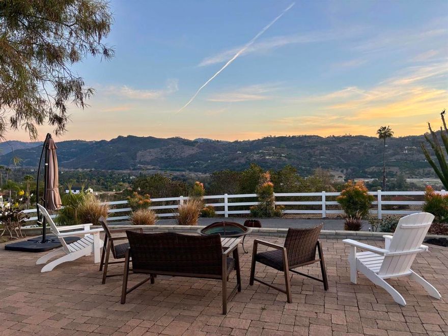 Sweeping panoramic views and peaceful countryside living await at this private, gated, single-story home nestled in the hills of Bonsall. The property offers expansive vistas of Moody Creek Horse Farm and the Hialeah Hills, with views that stretch far beyond, creating an unmatched sense of space, beauty, and tranquility. Set on just under 1.7 fully fenced acres, this hilltop sanctuary captures stunning sunsets and exceptional privacy, with few neighbors in sight. The home features three spacious bedrooms and two and a half bathrooms, including a newly remodeled primary suite bathroom. Inside, hardwood floors flow throughout open, sun-filled living spaces. The living room showcases mountain views, and the dining area opens to a covered patio through sliding glass doors, perfect for seamless indoor-outdoor living. Outdoors, enjoy a wraparound driveway with ample parking, a covered side patio for evening dinners, and a front patio ideal for morning coffee and sunrise views. The backyard features a newly landscaped grassy area and an elevated view patio. There are numerous spaces to relax, entertain, or consider adding a pool or ADU. The property includes just the right number of avocado and citrus trees for personal use, easy to care for yet productive. A truly special Bonsall retreat, this home offers the best of Southern California countryside living, tranquil, scenic, and move-in ready, with endless potential for the future.