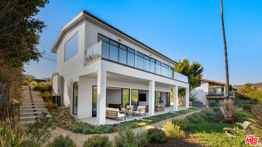 Discover the epitome of modern Malibu living at 6656 Dume Drive, a refined coastal retreat nestled in the heart of the prestigious Point Dume enclave. This stunning residence blends contemporary elegance with the relaxed charm of California's coastline, offering breathtaking views, seamless indoor-outdoor living, and exquisite design details. Adding to its allure, the property includes coveted beach key access, granting private entry to Malibu's most iconic sandy shores.The open floor plan creates a seamless flow between the living, dining, and kitchen areas, enhanced by floor-to-ceiling glass doors that frame sweeping views of lush landscapes and distant mountains. The open-concept living area boasts soaring ceilings, a sleek linear fireplace, and a neutral palette, creating a tranquil ambiance that perfectly complements the natural surroundings.The state-of-the-art kitchen is a masterpiece of design and functionality, featuring custom wood cabinetry, luxurious Taj Mahal stone countertops, high-end Wolf appliances, and a sleek see-through refrigerator. A spacious island with bar seating anchors the space, while the adjacent dining areabathed in natural lightinvites effortless entertaining. The same exquisite Taj Mahal stone extends into the powder room, adding a refined touch of elegance.The primary suite is a private sanctuary, complete with a large deck that captures stunning ocean views and a spa-like en-suite bathroom featuring a free-standing soaking tub. Each of the home's three bedrooms is designed for comfort and privacy, offering en-suite bathrooms and outdoor deck space to enjoy the serene surroundings.Designed for ultimate relaxation, the home's expansive balcony and lower-level patio extend the living space into the outdoors. Lounge in the beautifully landscaped backyard, gather around the alfresco dining area, or unwind in the serene seating spaces overlooking Malibu's picturesque terrain.Located in one of Malibu's most sought-after neighborhoods, this exquisite property offers close proximity to private beaches, scenic trails, and vibrant local hotspots. With its exclusive beach rights, ocean-view deck, and unparalleled design, 6656 Dume Drive is a rare gem offering the very best of Malibu's sophisticated lifestyle.