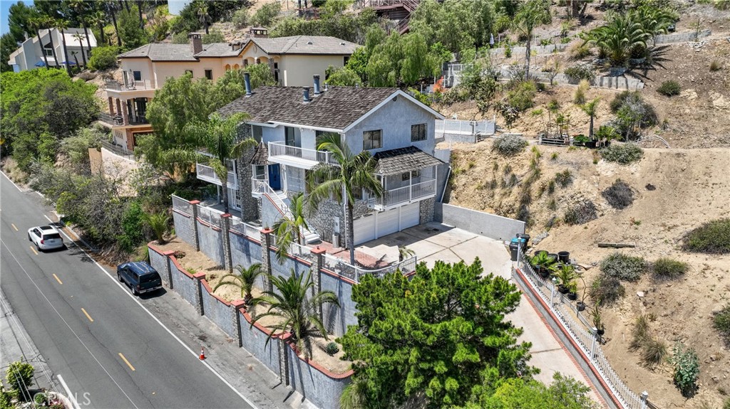 PANORAMIC VIEWS, LAND, and LOCATION. These are three characteristics which make this a unique and special offering. There are two properties being offered as a package deal; 12235 Circula Panorama Pl and the adjoining vacant lot at 12233 Circula Panorama Pl. Located in the highly desirable North Tustin community of Panorama Heights, this 4 Bedroom 3.5 Bathroom home includes a combined lot size of 32,310 square feet. The views are directly south facing, and on a clear day you can see all the way to Catalina Island! Nearly every room of the house offers stunning views. Move into the home as is, add onto the home to create your dream estate, build a second house on the vacant parcel, let your imagination run wild. The main level features a family room with soaring ceilings, a fully renovated kitchen with quartz counters, a double oven, and an oversized island. Upstairs there is the primary bedroom with en suite bathroom, 2 secondary bedrooms, and an additional full bathroom. On the ground level, there is a bedroom, full bathroom, and separate living area. There is a private access from the ground level, which could be a perfect set up for a mother in law suite or a junior ADU. There is a 3 car garage, a long driveway, and designated private parking on the street. One of the highlights of this community is its perfect location in Orange County; a quick drive to John Wayne Airport, Newport Beach, Peter’s Canyon Regional Park, and just 45 minutes to downtown LA. Come and see one of the most unique offerings on the market!