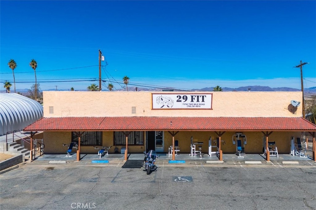 ***29 FIT***FREE-STANDING 4,200SF COMMERCIAL BUILDING + ADJACENT LOT***
Located in the downtown core of the City of 29 Palms, this free-standing 4,200-square-foot commercial building includes paved on-site parking and an additional, adjacent commercial lot, for a total of 29,648 square feet of land (0.68 acres). Both parcels are zoned CG by the City of 29 Palms. This property is situated at the northwest corner of Two Mile Road and Palo Verde Road, and is visible from Adobe Road. The building is currently operating as a fitness center/gym. The gym equipment and business is also available. It is improved with gym flooring, overhead commercial lighting, high ceilings and men's and women's locker rooms. The main parcel also includes a quonset hut building being used as part of the fitness center. The gym equipment and business is included.