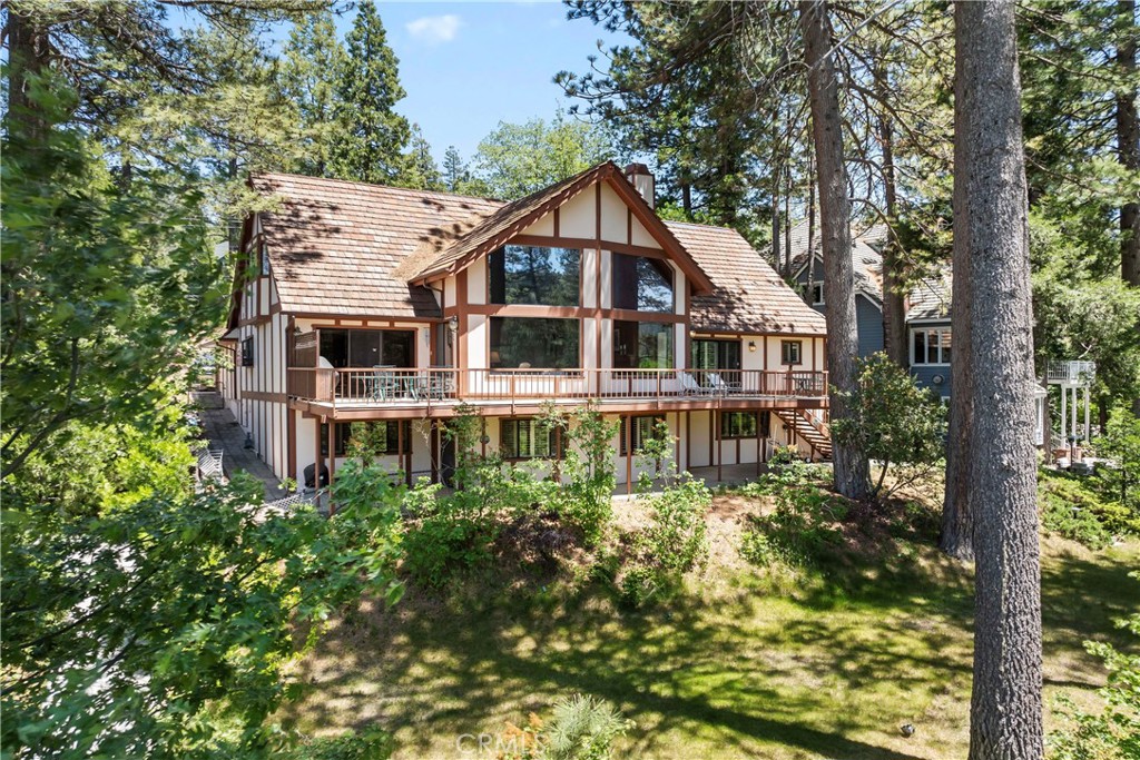 Welcome to this Beautiful and Charming Golf Course Frontage Home! This beautifully maintained 5-bedroom, 5-bathroom residence offers level entry, breathtaking golf course views, and direct course access—making it a true golfer’s paradise! Nestled in a prime location near the Lake Arrowhead Country Club, this property blends classic charm with thoughtful design details throughout. Warm wood accents, stonework, and oversized casings complement the abundance of natural light, creating a cozy yet elegant atmosphere. The main family room features vaulted, beamed ceilings and serene lake views, setting the tone for comfort and relaxation from the moment you step inside. The main level includes a spacious kitchen with adjoining dining area, a deep 2-car garage, and two generous primary en-suites. Step out onto the rear deck to soak in the unobstructed golf course views—great for morning coffee or evening gatherings. Upstairs, you'll find three additional bedrooms and a secondary living room with panoramic views of the lake fountain and #2 green—wonderful for hosting family and guests. The lower level boasts a large game room, another bedroom, a cozy living area, and a bonus room packed with entertainment options. There's also a fenced dog run and lower patio area, offering more space to enjoy outdoor living. Plenty of extra parking. Landscaped. Whether you're looking for a full-time residence or a luxurious retreat, this home offers the perfect blend of comfort, access, and the golfing lifestyle. With its premier golf course frontage and proximity to Lake Arrowhead’s best amenities, this is a rare opportunity not to be missed!