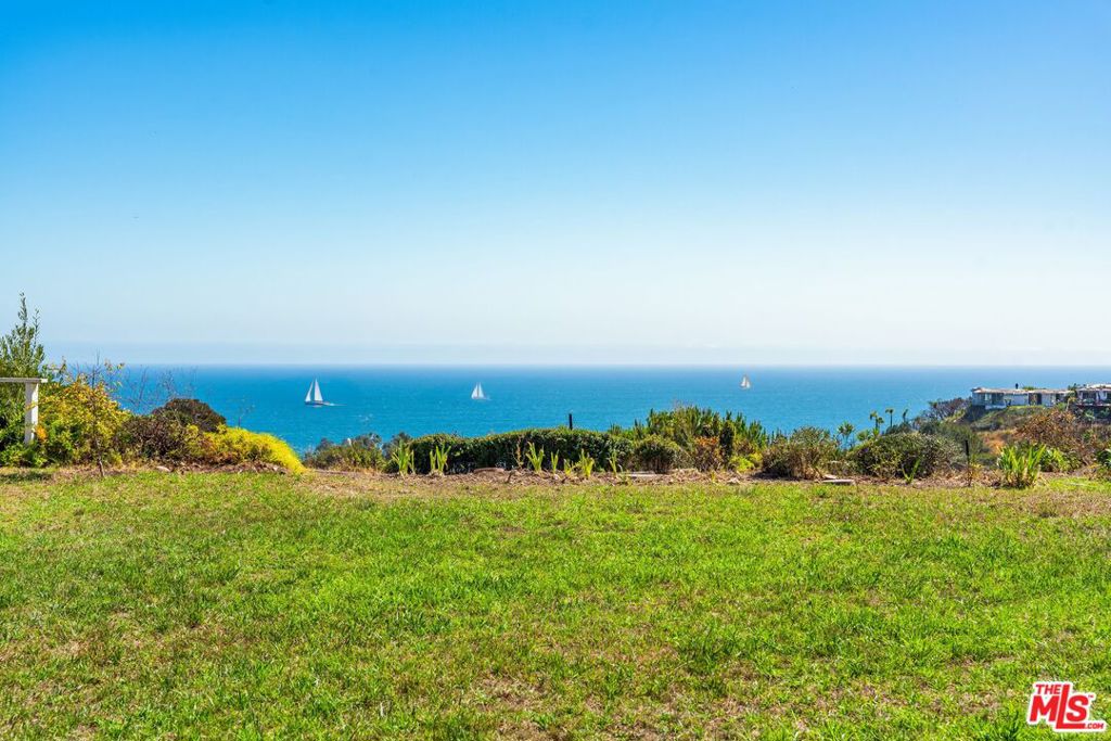 Perched just above the Getty Villa in Pacific Palisades, this Pacific View Estates retreat is now available for the first time EVER! Only moments from Sunset Blvd @ PCH and Gladstones, and just a block to the beach. A classic 60s ranch commands wide frontage and a deep half-acre lot, with an enormous private flat pad in this prime, groomed enclave with underground utilities and wide streets, largely untouched by recent fires. See the sailboats on the Pacific from the house, hear the waves and birdsong carried through the canyons & coastal air, giving a sense of calm and connection to nature, yet so close to town. With close to 3,000 square feet, the 5 bedroom/3.5 bath residence unfolds with classic Mid-Century flow, including a large foyer leading to interconnected open concept public spaces: living room with fireplace, dining room, and family room with a wet bar, each steps away from the wide patio, grassy yard, canyon, and alluring ocean views. A generous kitchen includes a breakfast area and adjacent 5th bedroom/maid's quarters with bath (more ocean views), perfectly positioned for creative, minor floor plan adjustment whether as a den, office, enlarged kitchen, or other use. The private wing of the home offers 4 bedrooms (3 + convertible den) and 2.5 additional baths, including an extensive primary suite with walk-in closet, providing quiet separation from the main living spaces and direct garden access with views. A large, direct access 2-car garage and original circular driveway option (2 curb cuts remain in the broad front yard) complete the offering. Payment of nominal, optional HOA dues to the Pacific View Estates HOA (waived in 2025) provides annual passes to the Getty Villa for residents and guests without reservations. Whether thoughtfully updated or completely reimagined, here is your opportunity to create a legacy estate in one of the Palisades' most coveted enclaves.
