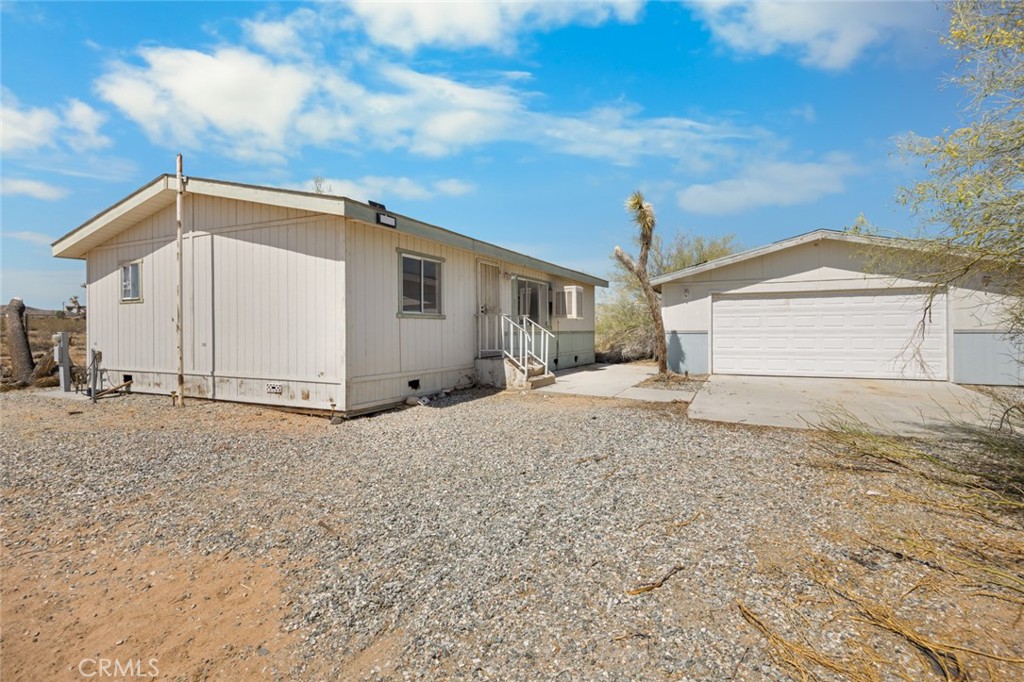 Viewing straight out at Goat Mountain, this manufactured home fixer with a very well built, large garage is located in a great part of Landers. If you've got the skills this can be a low cost of entry to home ownership. The home and garage are fenced. The 5 acre lot is not far from the paved road. It'll take some work but there are things to work with here! Worth the effort.