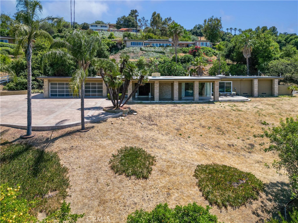 Price Adjusted... Near the South Hills Country Club... So, if you like golf, become a member & you can easily make your way & take a swing or enjoy the social activities found there such as swimming, tennis, fitness & more.
The property offers a sense of privacy w/ the gated access off from Virginia Lane that is abut from Spring Meadow. A gentle bend in the driveway takes you to a spacious area to park as well as the 3 car garage. Instantly, you will recognize how special it is by entering through the double doors w/ original large adorned handles that has aged beautifully w/ a rich patina.
A formal entry awaits for you to greet guests when it is time to entertain. Note the terrazzo tile in the entry that will compliment the common living area located around the smooth curved wall that adds to the charm. The formal living & dining is set w/ sliders & features a view of the foothills. A couple skylights & recently updated LED lighting throughout helps illuminate the rooms beautifully. A wet bar is situated between the common living area & casual dining w/ sliders to the backyard and updated lighting adjacent to the kitchen. The common living is a standout w/ the terrazzo flooring & rock accented wall at the fireplace & floor to ceiling windows framing the foothills for you to take in.
The kitchen w/ updated lighting has a gas stove top & a built in oven & microwave & the refrigerator remains. There is seating available at the island & ample storage space is found not only in the cabinets topped w/ quartz counters, but the walk in pantry as well.
There are two main bedrooms w/ en suite & walk in closets. One is on the opposite wing from the rest of the bedrooms & has its own A/C unit w/ two sliders: towards garage and backyard. This setup would be ideal for multigenerational use if needed.
Across from the powder room w/ new fixtures & mirror is the primary bedroom w/ an amazing view of the foothills & sliders to the patio to enjoy the scene. There is plenty of space for your clothes in the walk in closets right before the main en suite. You will notice how roomy it is with the oversized shower, double sinks, jacuzzi tub & commode w/ distance between them all.
Pass the laundry room w/ built in desk & door to the backyard, are the remaining two bedrooms w/ a shared bathroom. There is no lack of space for all to appreciate.
Experience it yourself and see if this is the one for you while taking in the stunning views.