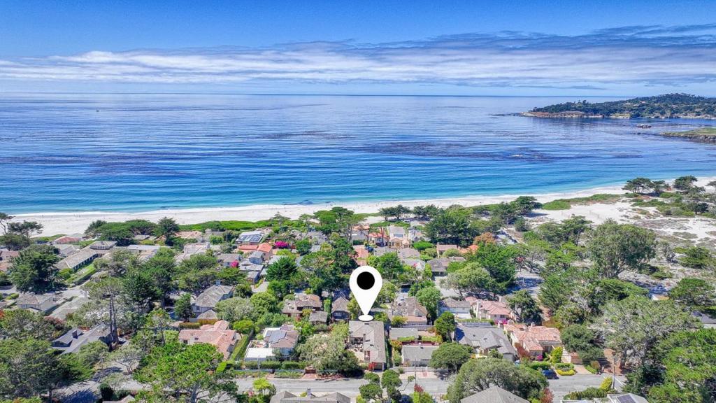 Nestled on the charming street of Carmelo with some peeks of the ocean, just a short stroll from Carmel's world-class beach and storybook downtown, this designer residence blends timeless style with modern comfort. Tucked away for added privacy, the home offers 3 bedrooms, 3.5 bathrooms, and 2,242 sq. ft. of beautifully finished living space. Inside, the inviting living room provides a cozy retreat, while the open, flowing floor plan seamlessly connects relaxed everyday living with elegant entertaining. The kitchen and baths are appointed with refined, neutral finishes, and each bedroom is thoughtfully designed to offer peace and serenity. Outdoors, lush greenery frames the property, creating a private oasis perfect for indoor-outdoor living. Enjoy your morning coffee or an evening glass of wine on the patio, gather with friends around the outdoor fireplace, or simply unwind under the stars and soak in the quiet charm of Carmel's beach town lifestyle. With its architectural details, generous layout, and unmatched location within walking distance of Carmel's beach and downtown, this home is an ideal primary residence or a perfect weekend getaway.