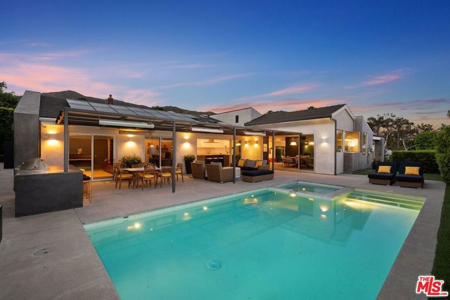 Experience luxury living in this newly remodeled contemporary residence, showcasing breathtaking ocean and Queen's Necklace views. Situated in the prestigious Country Estates neighborhood.  A meticulous complete renovation by Italian owners, featuring high-end imported materials and fixtures.Designed with a seamless single-story open floor plan, the home is thoughtfully divided into distinct day and night areas. The grand double-door entry leads to an expansive living, dining, and entertaining space with floor-to-ceiling doors that open to the front yard, inviting in natural light and stunning coastal vistas. Pocket doors in the dining and kitchen areas create a seamless indoor-outdoor flow, perfect for alfresco dining and entertaining.Crafted for hosting large gatherings, the outdoor space includes a heated patio, built-in barbecue, and a saltwater pool and spa. The private night wing boasts four generous bedrooms, including a sumptuous primary suite with both indoor and outdoor walk-in showers. Additionally, the home features two offices and a versatile media/exercise room.Sustainability meets convenience with a full solar energy system and a spacious three-car garage equipped with a Tesla charger and extensive storage. The beautifully landscaped grounds provide privacy and tranquility, all while being moments from Pepperdine University and nearby tennis and pickleball courts.A rare opportunity to own a meticulously designed home that blends modern elegance with coastal sophistication.