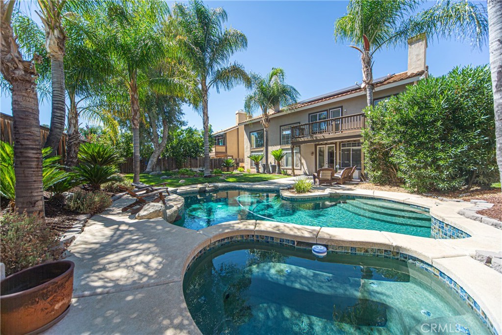 Rare opportunity to own a pool home with a lush, tropical yard as well as low taxes and no HOA and a three car garage conveniently located in Central Murrieta. This 4 bedroom, 3 bathroom beauty showcases soaring 20 foot ceilings when you enter through the double French doors and a sweeping staircase, picture windows with tons of natural light and views to the pool. The remodelled kitchen has granite counters and stainless steel appliances as well as a dining area with new light fixture. This opens to the spacious family room featuring a fireplace and custom built-in. The slider opens to the covered patio with an outdoor kitchen and the heated pool and spa with natural rock features as well as lawns with mature plantings and shade trees and palms. There is a main floor bedroom, currently set up as an office, and full bathroom with walk in shower. The living and dining room combo has lots windows for light and a fireplace. The dramatic double door entry to the the master bedroom with a tray ceiling and a french door to the balcony features a custom tiled bathroom and 3 closets. The spacious second level also 2 large bedrooms which share a Jack and Jill bathroom though each has their own private vanity area. Located between the 15 and 215 freeways, just off Clinton Keith, for easy freeway access and well as clsoe to shopping and schools with super low taxes.