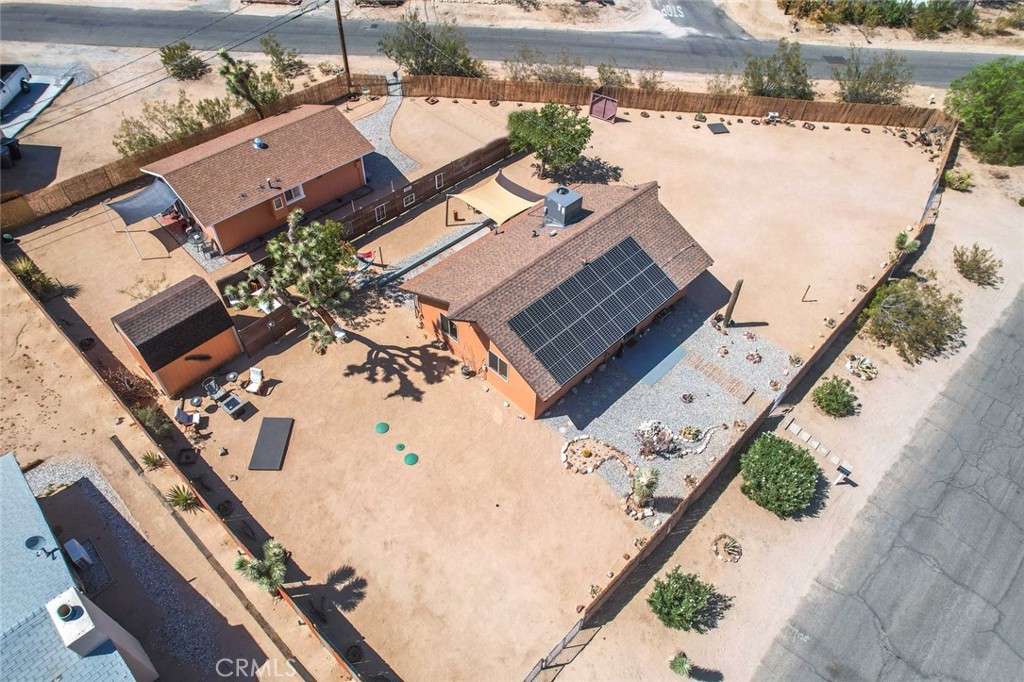 TWO HOMES on one parcel! Both permitted, one as a Single-Family Residence (SFR) and the other as a Guesthouse (ADU). Main house is a 2-bed, 1-bath; guesthouse is a 1-bed, 1-bath – for a total of 3-bedrooms and 2-bathrooms. Located in the village of Joshua Tree, within walking distance to the Farmer’s Market, shopping, dining and drinking. Also, walking distance to several wilderness hikes. Fully-fenced corner lot. Both homes have been remodeled and updated, including a new septic tank. Guesthouse has ductless mini-split AC/Heating Property also includes an electrical outlet for an RV. Mature landscaping with drought resistant desert plants. 10’x12’ storage shed. Large windows in the front of the main house provide natural lighting and spectacular views of Joshua Tree National Park. Property sits higher than the rest of the neighborhood to the south, providing unobstructed views of the mountains in the Park. Rent one to help pay mortgage, live in the other. Rear house is currently rented. (Furnishings not included in sale.) Quintessential Joshua Tree vibe. Must see to appreciate.