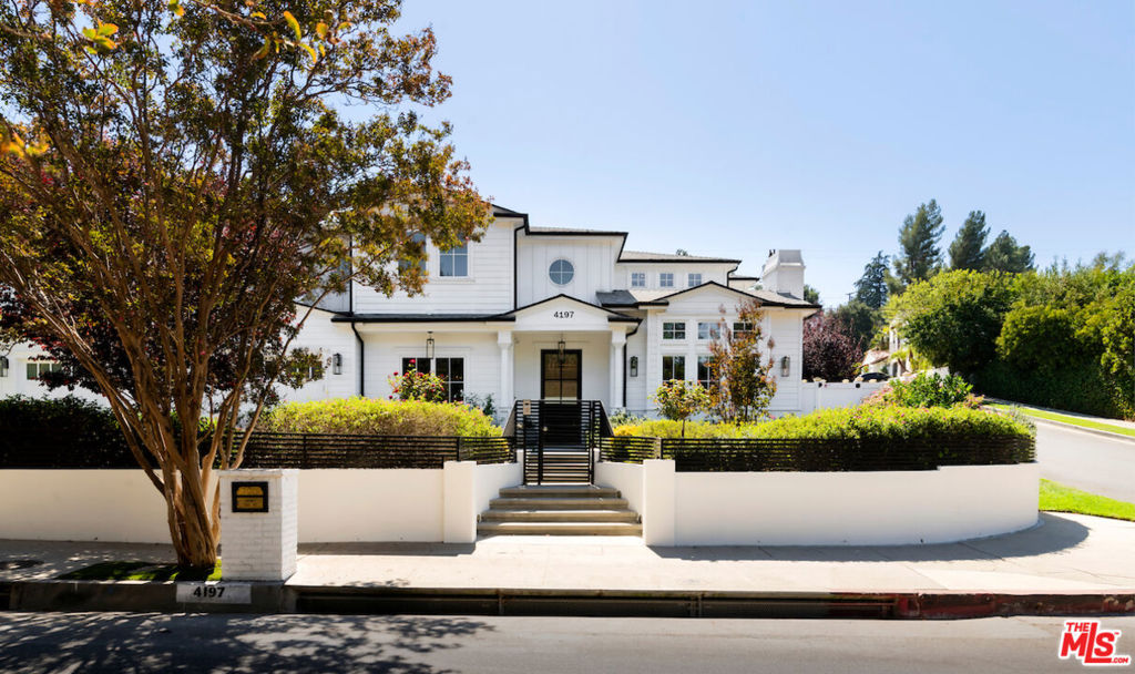 Set on peaceful Hayvenhurst Drive, this gated Cape Cod-style home combines exceptional craftmanship with privacy on a spacious corner not. A striking 22-foot entry leads to refined living and dining areas, a gourmet kitchen with two center islands, and a great room with bi-fold glass doors for a seamless spa-like bath, and two custom walk-in closets, alongside three additional bedrooms. The backyard oasis offers a saltwater pool, spa, fire pit, BBQ, and multiple patios, with a versatile pool house perfect as a guest suite, office or studio. With Control 4 automation, a three-car garage, and proximity to Lanai Road Elementary, this home is the epitome of quality and style.