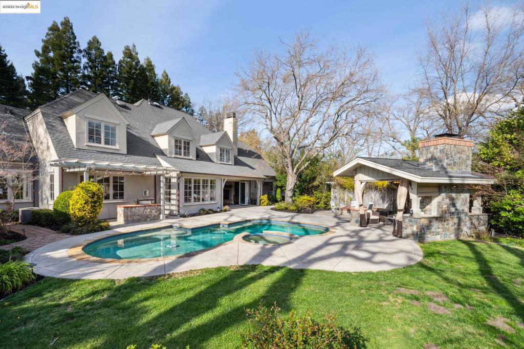 Located in Lafayette’s prestigious Hidden Oaks neighborhood, this European-inspired estate impressively blends Tudor and French Country elements including stone, brick, & stucco siding and a steeply pitched roof with gable windows. The home is surrounded by meticulously landscaped grounds. Inside, soaring ceilings and abundant natural light highlight the refined craftsmanship throughout. The grand foyer leads to an open-concept living space anchored by a grand fireplace, double height ceilings and bi-fold doors. The recently updated chef’s kitchen is equipped with a Viking range, built-in refrigerator, custom cabinetry, and central island. The gorgeous rear yard features a swimming pool & spa, covered patio lounge, lawn, built-in grill, firepit, mature landscaping, & multiple seating areas. Two separate garages provide ample storage and parking (the 1-car garage is poised for use as a home gym or detached office). The home is situated in a quiet cul-de-sac setting just minutes from top-rated schools, downtown Lafayette, and freeway access.