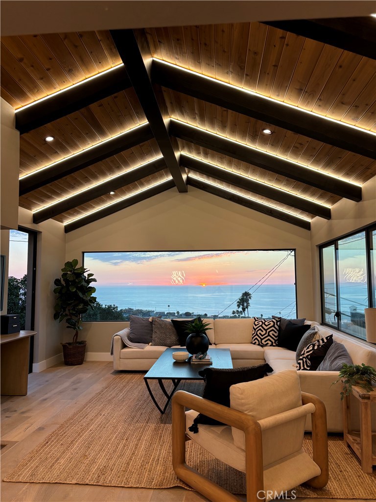 Another O.Rhyan Designed home, a Contemporary coastal ranch with modern farmhouse elements. The dark vertical siding paired with warm wood garage doors and trim provides a strong contrast and upscale curb appeal; Linear sconces add modernity and make the exterior glow at dusk, emphasizing architectural lines. A new horizontal cedar fence frames the lot, blending with the wood tones of the home. Minimalist landscaping (gravel, succulents, and low-water plants) suits a coastal climate and low-maintenance lifestyle.
This coastal luxury retreat in the Hollywood Riviera has been newly reimagined to blend modern design with timeless finishes, offering three bedrooms and three bathrooms across an open floor plan filled with natural light. Sweeping ocean and sunset views define the living experience, with expansive picture windows and sliding glass doors connecting every major space to the outdoors.
The rear living room is the architectural highlight, featuring vaulted ceilings with exposed wood beams and custom integrated LED lighting that accentuates the dramatic wood-plank detail overhead. A seamless flow leads into the dining area and designer kitchen, where quartz counters, premium stainless steel appliances, custom cabinetry, and an oversized island create a stylish and functional space for both entertaining and everyday living.
The private master suite opens directly to the deck and includes a generous walk-in closet and a spa-style bath with dual vanities, modern tilework, and a walk-in shower. Two additional bedrooms and two full baths provide flexibility for guests, family, or office use.
Outdoor living is equally impressive, with multiple view decks oriented toward the Pacific, blending indoor comfort with breezy coastal elegance. The contemporary exterior showcases stone and wood accents, complemented by drought-tolerant landscaping and a two-car garage with custom doors.
Located just moments from Riviera Village, sandy beaches, dining, and award-winning schools, this residence embodies the best of Southern California coastal living. Due to the numerous inquiries during the development of this home, it is not expected to stay on the market long. Hurry, this one won't last.