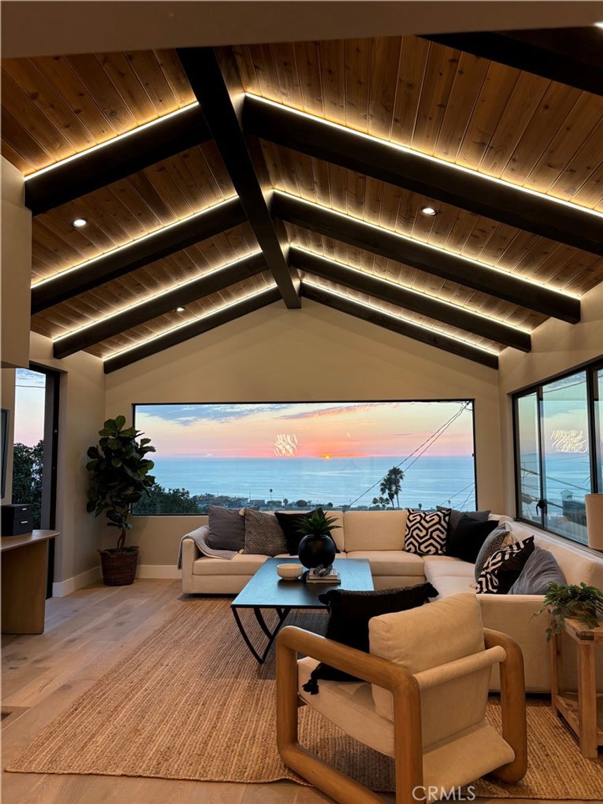 Another O.Rhyan Designed home, a Contemporary coastal ranch with modern farmhouse elements. The dark vertical siding paired with warm wood garage doors and trim provides a strong contrast and upscale curb appeal; Linear sconces add modernity and make the exterior glow at dusk, emphasizing architectural lines. A new horizontal cedar fence frames the lot, blending with the wood tones of the home. Minimalist landscaping (gravel, succulents, and low-water plants) suits a coastal climate and low-maintenance lifestyle.



This coastal luxury retreat in the Hollywood Riviera has been newly reimagined to blend modern design with timeless finishes, offering three bedrooms and three bathrooms across an open floor plan filled with natural light. Sweeping ocean and sunset views define the living experience, with expansive picture windows and sliding glass doors connecting every major space to the outdoors.



The rear living room is the architectural highlight, featuring vaulted ceilings with exposed wood beams and custom integrated LED lighting that accentuates the dramatic wood-plank detail overhead. A seamless flow leads into the dining area and designer kitchen, where quartz counters, premium stainless steel appliances, custom cabinetry, and an oversized island create a stylish and functional space for both entertaining and everyday living.



The private master suite opens directly to the deck and includes a generous walk-in closet and a spa-style bath with dual vanities, modern tilework, and a walk-in shower. Two additional bedrooms and two full baths provide flexibility for guests, family, or office use.



Outdoor living is equally impressive, with multiple view decks oriented toward the Pacific, blending indoor comfort with breezy coastal elegance. The contemporary exterior showcases stone and wood accents, complemented by drought-tolerant landscaping and a two-car garage with custom doors.



Located just moments from Riviera Village, sandy beaches, dining, and award-winning schools, this residence embodies the best of Southern California coastal living. Due to the numerous inquiries during the development of this home, it is not expected to stay on the market long.  Hurry, this one won't last.