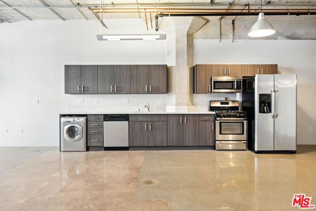 Live/Work in Style Iconic Arts District Loft with Private Patio! Here's your chance to lease a truly special space in the coveted and gated Beacon Lofts, a landmark building at the heart of Downtown LA's thriving Arts District. Originally built in 1923, this historic concrete structure was transformed through a $20 million architectural renovation into one of the area's most sought-after live/work loft communities. This bright, open concept loft showcases raw industrial charm with polished concrete floors, soaring ceilings, massive cement columns, and floor-to-ceiling windows that pour in natural light. The sleek kitchen features Quartz countertops and stainless steel appliances, while the spacious full bath adds modern comfort. Step outside to your expansive private patio, perfect for relaxing, entertaining, or working al fresco. Residents also enjoy a rooftop deck and spa lounge with BBQ and sweeping views of the city skyline. Beacon Lofts is a boutique collection of artist-style lofts, blending authentic industrial architecture with high-end finishes like dual-pane windows and exposed structural elements. Located just seconds from top galleries, breweries, coffee shops, and award-winning restaurants, this is where creativity and city energy come together. Available now. Experience the best of the Arts District. Make it yours.