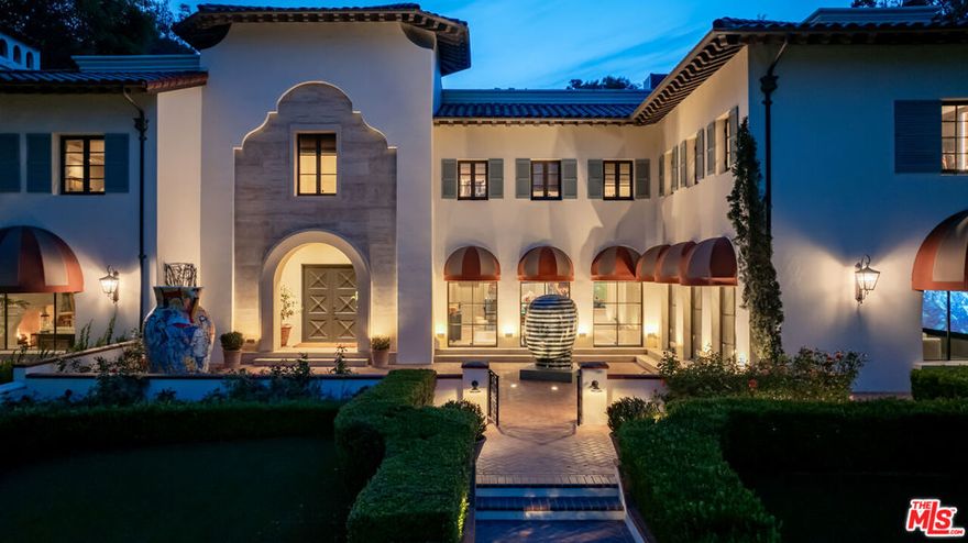 An Estate Fit for a Titan of Industry. Set high above the street behind incredible secure gates, this commanding European-style "Armani Casa masterpiece estate" exudes unmatched curb appeal and stature. A bold architectural statement, built for those who live and entertain on a grand scale. A sanctuary of sophistication using only the finest materials. Every detail was considered, every finish elevated. The scale is unmatched, from expanded interior walkways and massive walls perfect for large-scale art collections, to sculpture gardens, and majestic oak trees anchoring the rear yard with timeless beauty and shade. The home also features a gym rivaling top-tier fitness clubs, a travertine spa and massage room, and an industry-caliber movie theater built to impress. Built new in 2009 and reimagined by some of LA's most sought after designers, the estate features a dramatic formal entryway adorned with custom French Maison-G stone flooring throughout. Brazilian rosewood flooring with custom inlays, rich wainscoting, and elegant light accents. Marvel at the craftsmanship of the Italian & French stone/marble, herringbone wood floors, and exquisite lacquer finished hand-carved staircase and custom steel and glass doors with anti-break film for added security. A sprawling 2000 sf subterranean garage is ideal for a car collector. The elevator provides convenient access to all levels. The kitchen is a culinary haven, centered around a generous island with breakfast bar and outfitted with a full suite of top-tier appliances. Hidden staircases offer discreet access between the media room and the upstairs office, allowing a media executive to move seamlessly between work and leisure throughout the day. The lower level includes a private guest suite, full gym, spa, and massage retreat. Upstairs are four additional en-suite bedrooms, along with a spacious executive-style en-suite office with treetop views, offering the perfect blend of luxury and function. This home delivers Brentwood Park and Hancock Park quality in the heart of Royal Oaks, one of the Valley's most coveted neighborhoods. With grand entertaining spaces, museum-worthy walls for art, and irreplaceable outdoor features, this estate is in a league of its own and a rare opportunity to own a residence of true substance and scale.