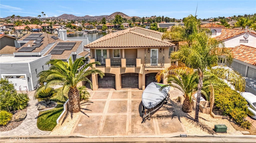 Welcome to 30420 Longhorn Drive, a stunning east-facing waterfront masterpiece located in the prestigious guard-gated community of Canyon Lake, CA. Perfectly positioned on the serene waters of Catfish Cove, this residence offers refined lakefront living with breathtaking panoramic views, exceptional design, and world-class amenities. Spanning an impressive 3,811 sq ft on a 6,098 sq ft lot, this home features a grand open floor plan adorned with soaring ceilings, travertine flooring, and designer finishes. The gourmet kitchen is a chef’s dream, complete with a large center island, Viking appliances, wine cooler, and spacious walk-in pantry—a perfect balance of function and elegance.
The luxurious master suite is a true private retreat, offering sweeping lake views, a cozy sitting area, private patio, in-suite fireplace, dual walk-in closets, and a spa-like ensuite with jacuzzi tub and oversized glass shower.
Outdoor Living at Its Finest-The resort-style backyard is an entertainer’s paradise, featuring an infinity-edge pool and spa with cascading waterfalls, multiple seating areas, and a private patio with built-in entertainment center. Enjoy a sandy beach area, large palapa, fire pit, and a covered u-dock with hydro lift—ideal for boating, paddleboarding, or simply soaking in the lakefront tranquility.
From the moment the sun rises over the water to the peaceful glow of evening, this property offers front-row views of majestic water and mountain vistas, fostering a daily sense of serenity and elevation. Designed for both grand entertaining and intimate moments, it seamlessly blends luxury and comfort.
In the celebrated Canyon Lake community—renowned for its privacy, safety, recreational amenities, and natural beauty—this home is more than a residence; it’s a lifestyle. Whether hosting unforgettable gatherings or enjoying quiet reflection by the water, 30420 Longhorn Drive is truly one-of-a-kind.