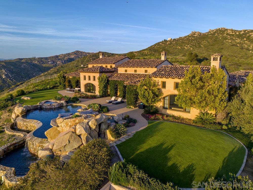 Nestled atop the mountains, this stunning Mediterranean villa boasts breathtaking 360-degree views and sits on approximately 5 acres of land within the exclusive gated community of The Heights. As you enter, you'll be greeted by soaring ceilings and doorways that create an airy, light-filled ambiance. The chef's kitchen is a culinary masterpiece, featuring sleek stainless-steel appliances, new marble countertops, and an inviting seating area. The family room is the epitome of open concept living, seamlessly connecting to the alfresco dining area with a built-in BBQ, pizza oven, and ample seating. One wing of the home offers a game room, movie theater, two ensuite bedrooms, a mudroom, and an oversized 4-car garage with plenty of storage. The spacious primary retreat is a true oasis, complete with a cozy fireplace, a sprawling bathroom with a jacuzzi tub and an oversized stone shower, new marble countertop vanities, and two water closets. The other wing of the home features two ensuite bedrooms, a laundry room, and an executive office with exquisite, chauffeured wood ceilings and paneling. The backyard is a dream come true, with an infinity-edge pool and spa with waterfalls, full tennis court and fenced in children's playground. This property offers complete serenity and privacy - a rare gem that must be seen to be appreciated.