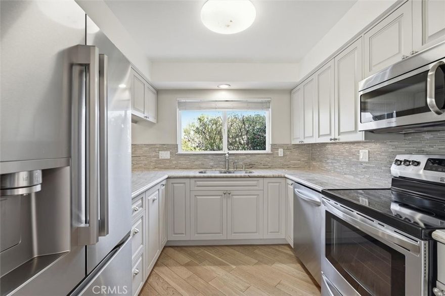 Welcome to this light-filled 2-bedroom, 2-bath Bungalow residence located in the desirable New Horizons 55+ community in Torrance. This type of patio-style home which rarely comes on the market features wood flooring throughout the main living areas and bedrooms, fireplace, fresh paint and an open, functional layout. The updated kitchen offers ample cabinetry, stone countertops, tile backsplash, stainless steel appliances and a window that brings in natural light. The spacious living and dining area opens to large sliding doors with plantation shutters that lead out to the covered patio space. Both bedrooms are generously sized and include ceiling fans and closet storage. The primary suite features an ensuite bath with stone finishes and a walk-in shower with designer finishes. The second bathroom is also well appointed with a full vanity and shower. Additional highlights include a large cedar-lined walk-in storage/closet space, recessed lighting, and a concealed area for a washer and dryer. Located within a beautifully landscaped, gated community offering resort-style amenities including golf, pool, spa, clubhouse, fitness center and organized activities. Conveniently situated near shopping, dining, medical facilities and easy freeway access.