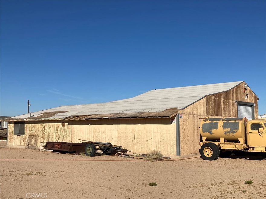This property is a Mechanic's dream.  It has a HUGE machine shop/mechanics shop with 220 three phase power, 3 roll up high clearance garage doors, 4 overhead chain fall electric hoists in area with high ceilings & room to park at least 3 cars.  The whole shop has been plumbed for air tools.  Nice neighborhood, centrally located in Newberry Springs but more towards the west side so closer to Barstow than some of the properties.  A 45 foot storage container will stay with the property but Seller will be taking the 14 foot container.  The lot is fully fenced and is on the NE Corner of & Coventry.  There is an older single wide 2 bdrm 1 bath mobile home on the property, it's not on a permanent foundation and is considered "personal property".  Seller doesn't have title to the mobile home.  It needs a lot of work but has a new service panel in the bedroom.  A new well, 320' deep with 5' casing was installed in December 2021 but never used.  Water level was at approximately 175'.  Pump, pressure tank, drop pipe & wire still need to be installed.  There is also an old well on the property but probably not salvageable.  Large pressure tank is for the old well & is in the tall shed to the left of the driveway.  This property is being sold in existing condition.  There are security cameras & a caretaker, drive by only or make appointment to show.  DIRECTIONS: From Barstow take 1-15 to East to Minneola Rd exit. Turn right, go 2.5 miles to Valley Center Rd, turn left.  Go 2 miles to Condor Rd, turn left.  Go 6 blocks to just past Coventry Street, the property is fenced & will be on your right.  Located on the NE corner of Condor & Coventry.  Enter from Condor Rd.