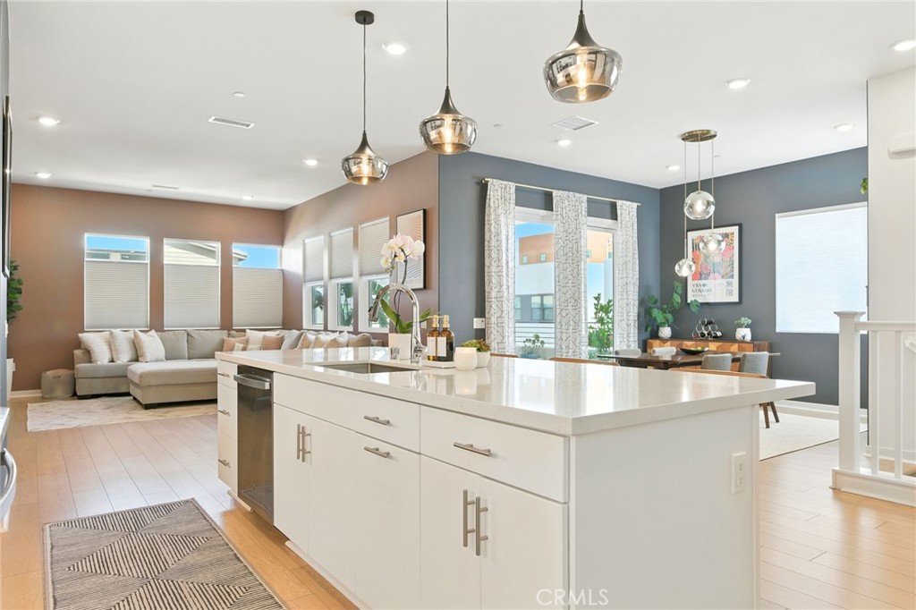 OWNED Solar! Step into style and sophistication in this beautifully upgraded home located in the vibrant and innovative community of FivePoint. Built in 2023, this contemporary 4-bedroom, 3.5 bathroom residence (PLUS Bonus Room and Office!) blends smart technology, sustainable features, and designer finishes for a truly elevated lifestyle. Inside, you're greeted by striking modern light fixtures and stunning luxury vinyl plank (LVP) flooring that runs throughout the main living areas of the home. The open-concept layout flows effortlessly into a sleek, chef-inspired kitchen featuring stainless steel appliances, a generous center island, walk-in pantry, various cabinets with glass panels and a beautifully upgraded modern tile backsplash that adds a special designer touch. Unwind outdoors with not one, but three outdoor living areas—including a spacious third-floor deck, thoughtfully attached to a 3rd floor loft, full bedroom and private bath! A two-car attached garage comes complete with an EV charging port and a tankless water heater for efficiency and convenience. In addition, modern features abound with the Ring doorbell, smart thermostat, keyless entry for the front door, garage opener keypad, MyQ smart garage door opener, Leviton smart light switches, and energy efficient dual paned windows. Living in FivePoint means access to a wealth of community amenities—from refreshing pools and scenic walking trails to playgrounds, a community garden, weekly farmers markets, and year-round events. With electric car charging stations and a strong focus on sustainability, this neighborhood is designed for modern living. Ideally located just minutes from the 5 freeway, top-rated schools, and popular shopping destinations, this home has it all—style, location, and lifestyle.