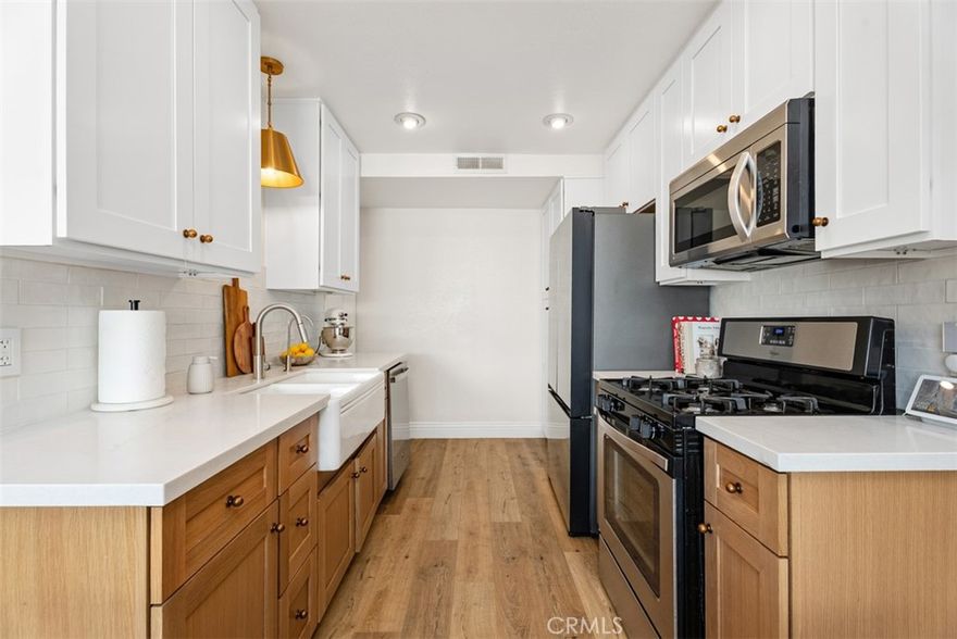 Experience Effortless Living! Impeccably Remodeled, Two-Level Townhouse in the sought-after Aliso Villas community. This residence offers 2 bedrooms, 1.5 bathrooms, and a convenient one-car garage with direct access. Inside, the home boasts a freshly painted interior with a spacious living room featuring newer vinyl plank flooring on the first level. The heart of the home is the immensely upgraded kitchen, featuring newer stainless steel appliances, newer quartz countertops, newer cabinetry, and newer hardware. It flows seamlessly into the dining area, which overlooks the private outdoor patio enclosed by vinyl fencing. Upstairs, you will find two generously sized bedrooms. The primary suite includes a walk-in closet, and the secondary bedroom offers ample closet space. The upstairs full bath and the downstairs half bath have both been recently updated, including newer toilets for both, plus a newer bathtub and marble tile in the upstairs bath. Infrastructure improvements include a newer water heater and updated plumbing. Beyond the direct-access garage, this home includes one assigned parking spot (space #985). As a resident of the Aliso Villas, enjoy access to a sparkling pool, spa, playground, and park. Also enjoy Mission Viejo Lake privileges! The location is ideal, offering close proximity to fantastic restaurants, the Mission Ranch Market, popular shopping destinations, and award-winning schools. This turn-key home is ready for you! Schedule your showing today.