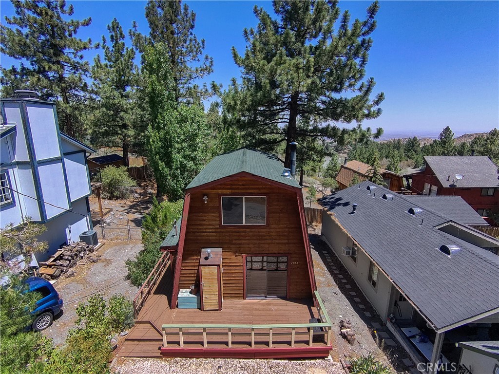 Welcome to 2068 Slippery Elm Rd, a stunning Gambrel Style Home nestled on the East Side of Wrightwood. This iconic mountain retreat offers the perfect blend of rustic charm and modern comfort, ideal for a weekend getaway or year-round living.
Perched among majestic trees, this property boasts breathtaking views of the high desert, creating a serene and awe-inspiring backdrop for your daily life. The flat lot provides ample parking and versatile outdoor space, limited only by your imagination.
Expansive front and rear decks seamlessly connect indoor and outdoor living, allowing you to fully embrace the mountain lifestyle. Step inside, and you'll be greeted by a spacious living room centered around a cozy fireplace, setting the tone for this exquisite home.
The well-appointed kitchen serves as a natural divide between the living room and dining area, perfect for entertaining or intimate family gatherings. Modern conveniences abound, including an indoor laundry room with complimentary appliances.
Indulge in the full bath's soaking tub, offering a luxurious retreat after a day of mountain adventures. Sliding doors at both the front and back of the home invite the crisp mountain air inside, while natural light floods the interior, bringing the outside in.
Ascend the beautifully crafted stairs to discover two lofty bedrooms on the upper level. The primary bedroom is a true highlight, featuring an elevated deck that showcases the desert panorama in all its glory.
With its prime location, 2068 Slippery Elm Rd offers the best of Wrightwood living. Surrounded by the soothing sounds of whispering pines and bathed in natural light, this home truly captures the essence of mountain living. Don't miss this opportunity to own a piece of Wrightwood paradise!