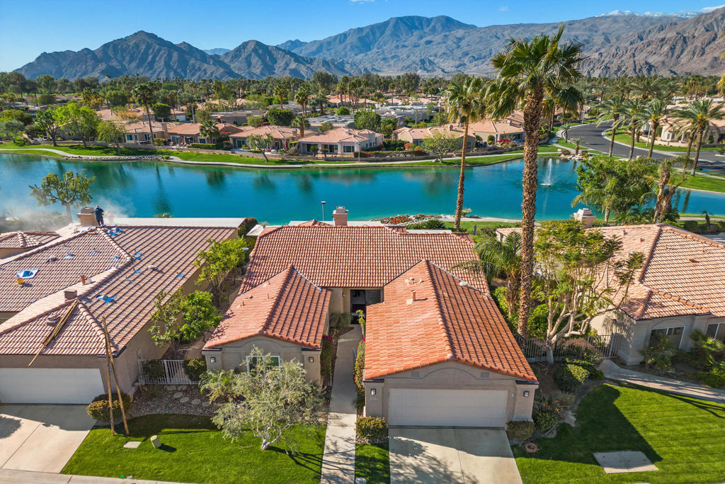 Spectacular Lake Front Property - A Rare Gem! This beautiful lake front property in Laguna De la Paz has everything you have been looking for! Featuring breath-taking lake front and mountain views this well-appointed and updated three bedroom, two bathroom home has all the amenities to help you live your dream. The open and spacious floor plan offers approximately 1,950 square feet of livable space, coupled with the best in outdoor relaxing venues. The living room includes a gas fireplace, custom built-in storage and patio access, while the dining room is a plus for formal dining and entertaining or everyday meals. The kitchen is a chef's dream with granite counter tops, upgraded appliances. Retire to the primary retreat that boasts a walk-in closet, patio access and a spectacular and luxurious en suite with both tub and seamless glass shower. Guest bedrooms are bright and offer additional living and sleeping space. The real treat is the amazing South facing outdoor space that includes a large patio area with private Spa which looks out on the lake as well as offering a stunning view of the Santa Rosa Mountains.. Laguna De La Paz offers a gated community with amenities that include a fitness center, clubhouse, lake, walking paths, tennis and pickleball courts, pools and spas and more. Fine dining, golf courses and shopping are just minutes away. Professional photography with more interior photos will be available 9/9/25.