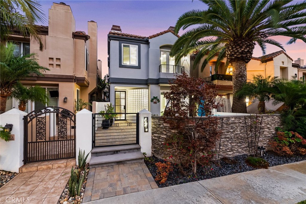Sophisticated Coastal Living in Downtown Huntington Beach. Experience the epitome of luxury in this fully remodeled, highly upgraded, stunning Ocean Pointe residence, ideally located just five blocks from the sand and crashing surf in one of HB's most coveted and serene enclaves. Spanning over 2,750 square feet of light-filled interiors, this home offers an impressive blend of refined design, thoughtful functionality, and timeless elegance. Step inside to discover a beautifully updated home featuring dual primary suites and three bedrooms in total, each with its own spa-inspired, recently renovated en-suite bathrooms and custom closet built-ins. One of the primary suites has a glowing fireplace and balcony with French Doors. Enter into an open living and room with fireplace and French Doors opening to the outdoor patio for alfresco dining. The separate, inviting family room adjacent to the kitchen that showcases a custom fireplace with new surround and bespoke built-ins, creating the perfect space for gathering and relaxation. The chef’s kitchen is a masterpiece—complete with an expansive quartz waterfall island, new designer backsplash, custom cabinetry, walk-in pantry, and professional-grade stainless steel appliances from Wolf and Sub Zero. Every detail has been considered, from the artisanal staircase railing to the custom lighting, dual-pane windows, motorized window coverings, and wide-plank wood-look porcelain flooring throughout. Modern conveniences include ductless AC with individual room controls, a tankless water heater, and a spacious upstairs laundry room. Enjoy seamless indoor-outdoor living with a professionally designed front patio featuring custom hardscape, lush landscaping, and designer lighting. A private third-level deck offers the perfect retreat for sunbathing or adding a spa for ultimate relaxation. The immaculate garage offers new epoxy flooring, EV charger, cabinets, overhead storage and glass garage door. There is a driveway in the rear to park an additional car. Nestled in a quiet location yet just moments from the beach, Pacific City, award-winning schools, the pier, and vibrant downtown dining and entertainment—this is the perfect balance of luxury and coastal lifestyle. Immaculate and meticulously maintained - Turn-key ready for the next lucky owners!
