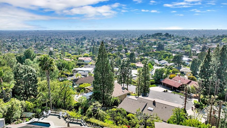 New Reduced Price for this custom estate home nestled in the hills of North Tustin. Boasting a large 7,622 sf open space floor plan for family living and entertaining, the home was designed by award winning architect Ron Yeo. Conceived for a family lifestyle with an emphasis on entertainment, upon entry into the foyer with a large crystal chandelier, the home opens to a living room with fireplace and dramatic 180-degree views of Tustin, Irvine, Fullerton and the Pacific. The adjacent dining room with crystal chandelier, kitchen with breakfast nook and outdoor patios are intimate and accessible. A copper fireplace provides a warm environment to the family room including a reading nook and direct access to the large pool deck. A convertible office/library incorporating another copper fireplace, built-in bookcase and outdoor patio is conveniently located just below the living room and entry foyer with direct stairway access. Entertainment highlights blend seamlessly with family elements with a sit-down bar with sink, dishwasher, refrigerator and media center. From this space it's just a few steps to the private wine tasting room with walk-in refrigerated wine cooler and outdoor deck. Directly adjacent is a fitness area with full length mirror and barre and small bar opening to a spacious family room, hot rock sauna and bath, with access to the outdoor decks and a resort style natural rock waterfall, solar-heated pool, spa and built-in BBQ, all with dramatic views. Upstairs bedrooms feature a large master with fireplace, outdoor deck and master closet with built-in island cabinet. The master bath impresses with a 2 head shower, spa tub, double sinks, garden feature, skylight and 2 chandeliers. Additional living space includes 2 en suite bedrooms with private patios, and a 4th bedroom with adjacent bath. Other unique features of this blended living space include a Zen garden retreat with water feature, 3 car garage with extensive built-in storage cabinets and workbench, integrated alarm and intercom system, central vacuum, 2 tankless water heaters, 4 furnaces, 4 a/c units, 2 skylights and hardwood floors to name just a few of the many luxury features of this estate. The home’s exterior was painted in 2023 with new decks installed in the last 3 years. A key safety feature provides crucial wildfire protection with an integrated roof sprinkler system and strategically located controls in the master bedroom and garage. Visit www.10841Hideaway.com