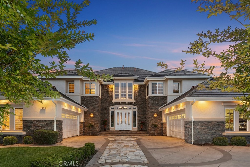 Welcome to 87 Panorama in the highly sought-after Pinnacle community on one of the most coveted streets in Coto de Caza. This exceptional estate with stunning curb appeal boasts the largest floorplan in the neighborhood at 5,449 sq ft. With 5 spacious bedrooms (1 downstairs), 5 bathrooms, large bonus room, office, and 4-car garage, this home is built for both comfortable everyday living and elegant entertaining. Step through the front door to soaring ceilings, an impressive dual staircase, and expansive windows framing the serene 360* mountain and valley views. The formal dining room and living room both open through sets of French doors, offering seamless indoor/outdoor flow. The updated gourmet kitchen is a chef’s dream, updated with top-tier appliances including a Viking range with 6-burner cooktop and griddle, Viking warming oven, built-in refrigerator, and a water filtration system. A massive center island with seating, walk-in pantry, built-in desk nook, and expanded eat-in dining area all open to the oversized family room. This builder-upgraded space features a stone fireplace, 80" 3D-capable TV, and a custom bar area with Thermador beverage fridge and ice maker—perfect for entertaining. Dowstairs also offers a private office/den, and a guest bedroom with full ensuite bath—ideal for multigenerational living. Upstairs, a spacious bonus room makes a perfect media or game room. One secondary bedroom has its own bathroom, while two others share a Jack and Jill layout. The opposite wing is dedicated to the luxurious primary suite with private balcony with mountain views, cozy sitting area, two walk-in closets, and a spa-like bath featuring dual vanities, two individual lavatories, a soaking tub, and a walk-in shower. The backyard is truly an entertainer’s dream, designed with multiple outdoor “rooms” for every occasion. The centerpiece is a sparkling pool and spa with waterfall and newly resurfaced Pebble Tec bottom. Enjoy the built-in bar with available beer tap and fridge, or relax in the side yard retreat with BBQ, quiet seating, and a fountain—set against sweeping views of the Coto Valley. On the opposite side yard, a former boat storage area is now a home gardener’s paradise with raised vegetable beds and a storage shed. From lively gatherings to tranquil mornings, this remarkable property offers it all. Residents enjoy access to world-class golf, tennis, equestrian facilities while having the security of a 24/7 gate guarded community.