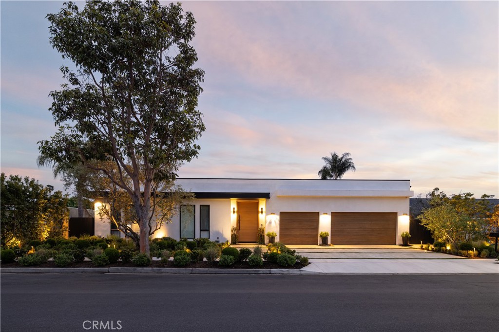 SHORT-TERM SUMMER RENTAL. Sleek modern design meets coastal ease in this approximately 3,713 square foot, single-level showpiece tucked on one of Baycrest’s most coveted streets. Step inside to a sun-drenched interior where skylights, 11-foot ceilings, and wide-plank white oak floors create an airy, open feel throughout. The great room is anchored by a stunning electric fireplace wall and flows seamlessly into a magazine-worthy kitchen outfitted with rift-cut oak cabinetry, a neolith-topped waterfall island, and high-end appliances including Dacor and a gallery beverage fridge. Just off the living room, a custom built-in bar with beverage drawers and a wine fridge enhances the home’s entertainment appeal. Oversized sliding doors disappear to reveal a true backyard retreat complete with pool, spa, water features, outdoor fireplace, built-in BBQ bar, and multiple dining and lounging zones perfect for entertaining or quiet evenings at home. This thoughtfully designed home features four en-suite bedrooms, including a luxurious primary suite with a spa-like bath boasting book-matched porcelain slab walls, dual vanities, frameless glass shower, and separate soaking tub. Further along is a stylish powder room and versatile bonus room with sliding barn doors and built-ins ideal for an office, media room, or playroom. Rounding out the property is an attached three-car garage, lush landscaping, and a quiet, tree-lined location just minutes from top-rated schools, the Back Bay trails, beaches, and Newport’s best dining and shopping.