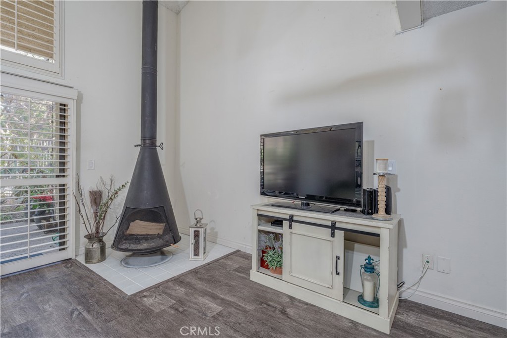 **FANTASTIC END UNIT (UNIT #24)** Welcome to your exquisite new home nestled in the stunning foothills of Orange, located in the highly sought-after Orange Lakes Community. This neighborhood offers charming water features, bridges, and lush, mature landscaping that creates a tranquil atmosphere. As you step inside, you are greeted by natural light that creates a cheerful, bright, and cozy atmosphere. The Mid-Century cone fireplace stands as a focal point in the main living area, serving not only as a source of warmth but also as a stylish conversation piece. NEW WOOD LAMINATE FLOORS and BASEBOARDS enhance the home, while the soaring ceilings add an element of sophistication. Just off the living room, a private patio awaits, providing a perfect oasis for relaxation after a long day or an ideal space for hosting friends and family during gatherings. The kitchen is a bright space featuring NEW REFINISHED COUNTER TOPS and ample cabinets that offer plenty of storage. A convenient serve-over bar invites casual dining experiences. Upstairs, you will discover the primary bedroom sanctuary, complete with an en suite bathroom with a NEW REFINISHED COUNTER, TUB, AND SHOWER ENCLOSURE, offering a spa-like retreat and a generously sized walk-in closet perfect for all your storage needs. For your convenience, a designated covered parking space, #90, is located just steps from your front door, and an additional parking spot, #130, is just a short distance away. The Orange Lakes Community boasts fantastic amenities, including a refreshing pool, rejuvenating spa, and tennis courts for your enjoyment. Ideally situated, this community provides quick access to Chapman University, the scenic Peters Canyon, Irvine Park, major freeways, and toll roads, not to mention an array of shopping, dining, and the charming historic district of Old Town Orange.