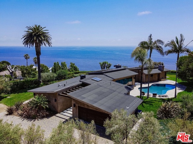 Your private Malibu hideaway awaits! This elevated Midcentury Modern architectural gem sits atop a bluff on a mostly flat acre of land behind a private gate. Marvel at jaw-dropping 270 degree ocean and mountain VIEWS, including Catalina Island and the Queen's Necklace. Every room of this 3,278 sq. ft 3 BR/3 Full BA plus office/den home has views to enjoy. A contemporary design with hardwood floors, quartz and stone countertops, vaulted ceilings and retractable glass doors which open to a heated pool, jacuzzi, and large grassy backyard from the living room and primary bedroom, allowing for the best of indoor/outdoor Malibu living. Special features include: walk-in closets, full powder bath, huge laundry room, 2-car garage, 2 interior and 1 exterior gas fireplaces, wine fridge, brand new Kitchen-Aid fridge, all high-end appliances, solar panels for an extremely low energy bill, and more! Experience privacy without losing quick access to all the best amenities Malibu has to offer.